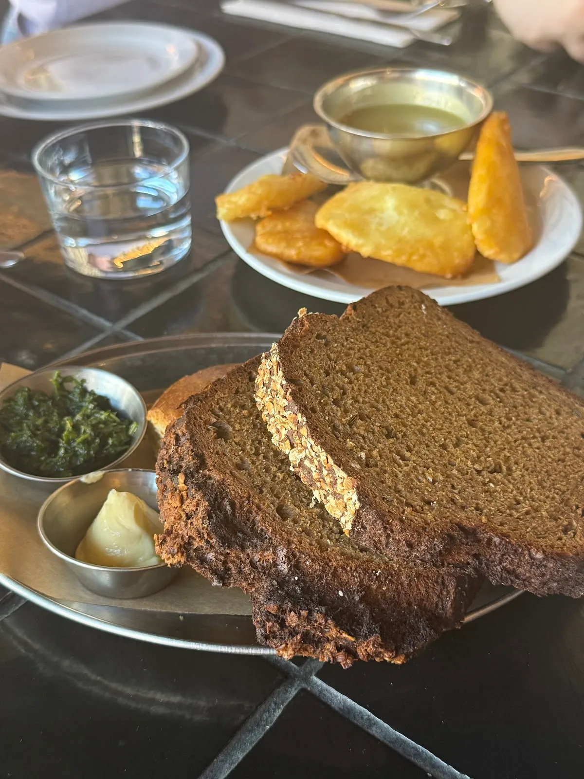 Slices of Irish brown bread with butter and creamed greens on the table at Inis