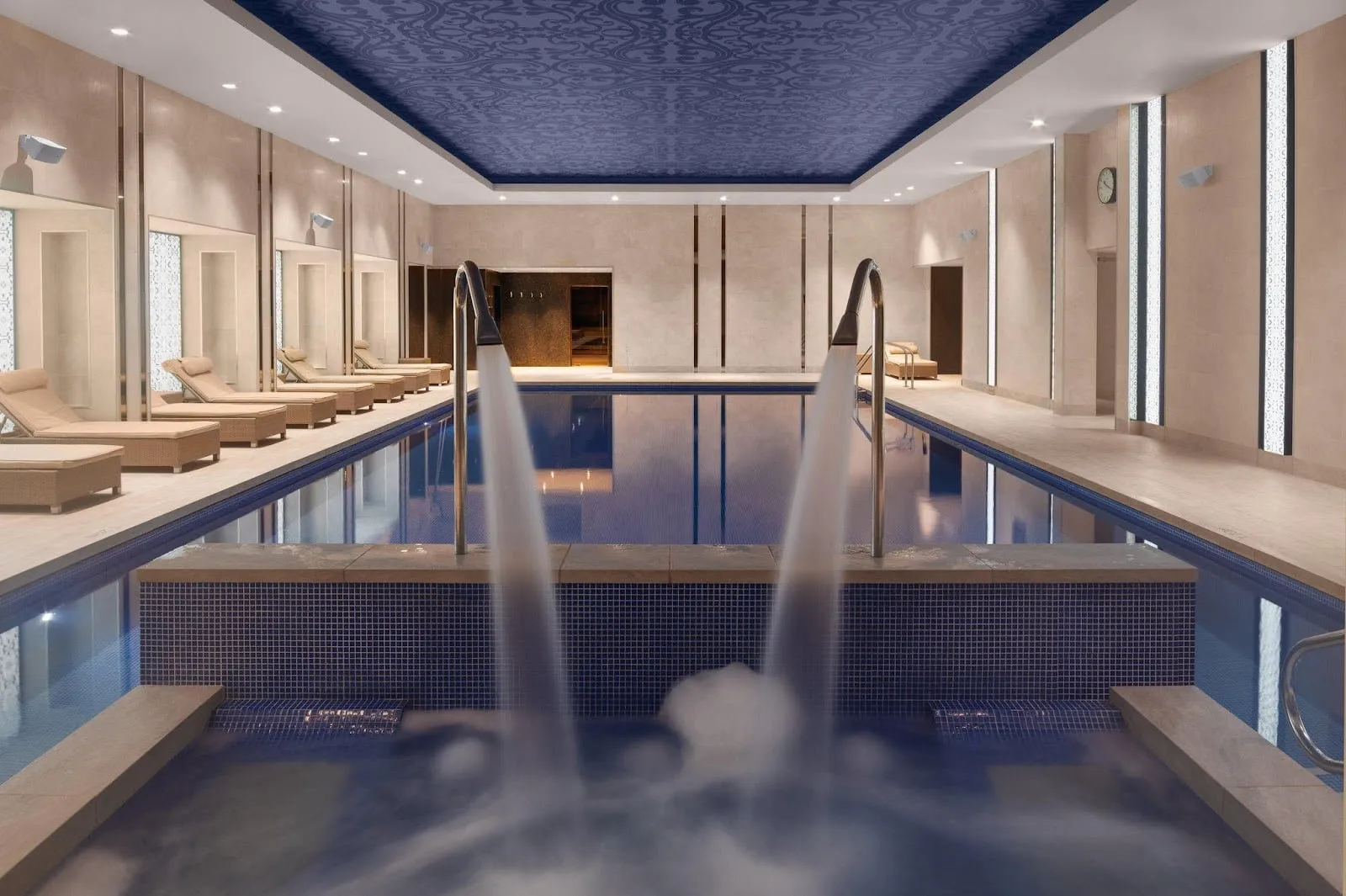 The indoor pool at InterContinental London – The O2, with two water jets and loungers along one side
