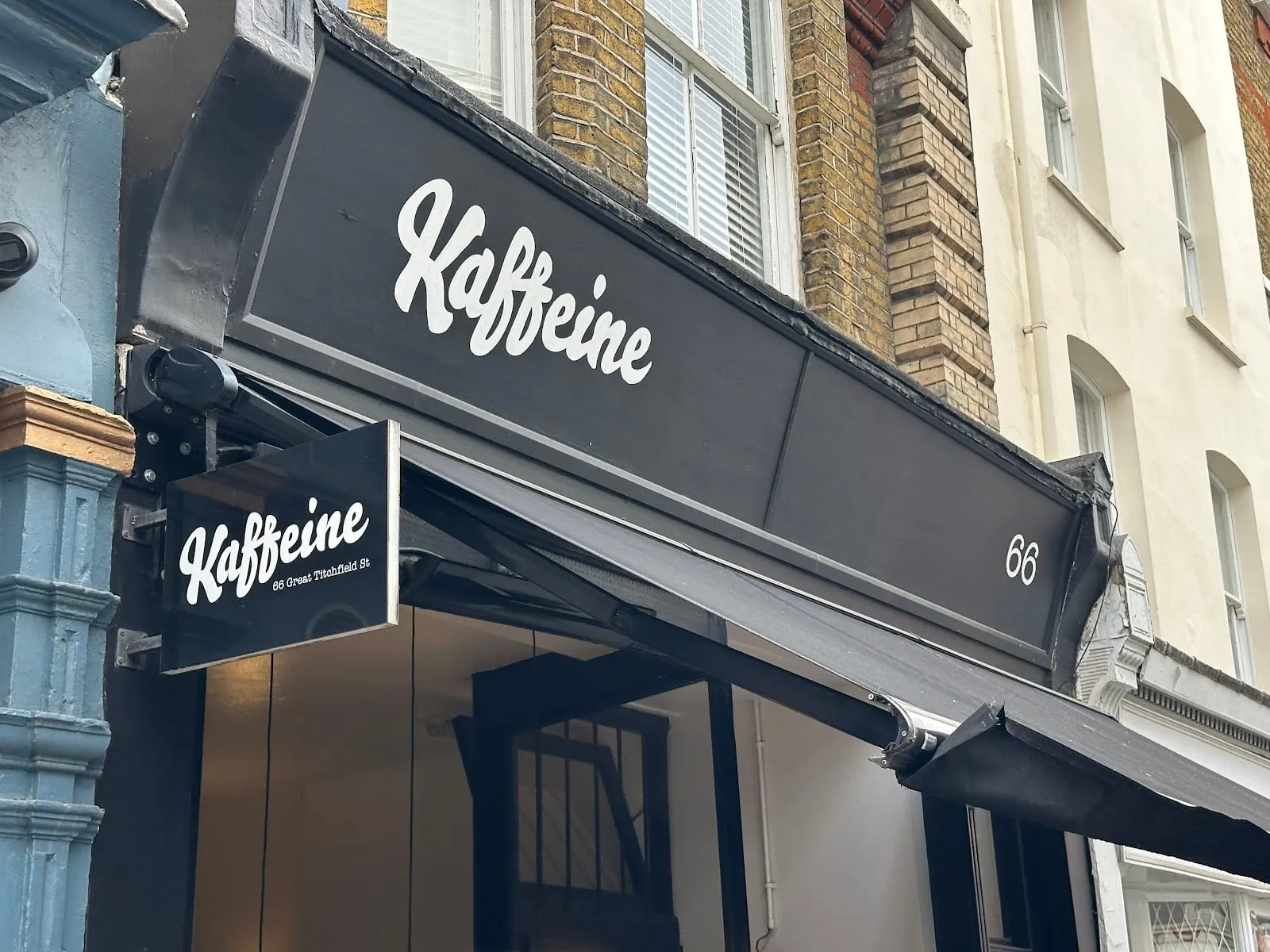 Kaffeine's black shopfront sign at 66 Great Titchfield Street