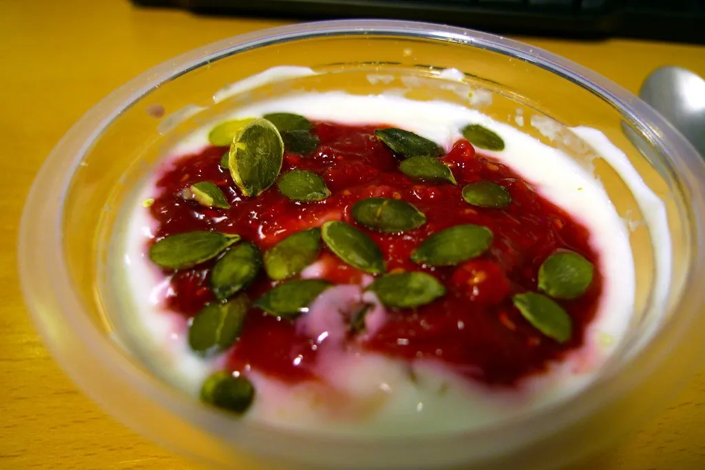 A slice of tart with a green salad on a wooden counter