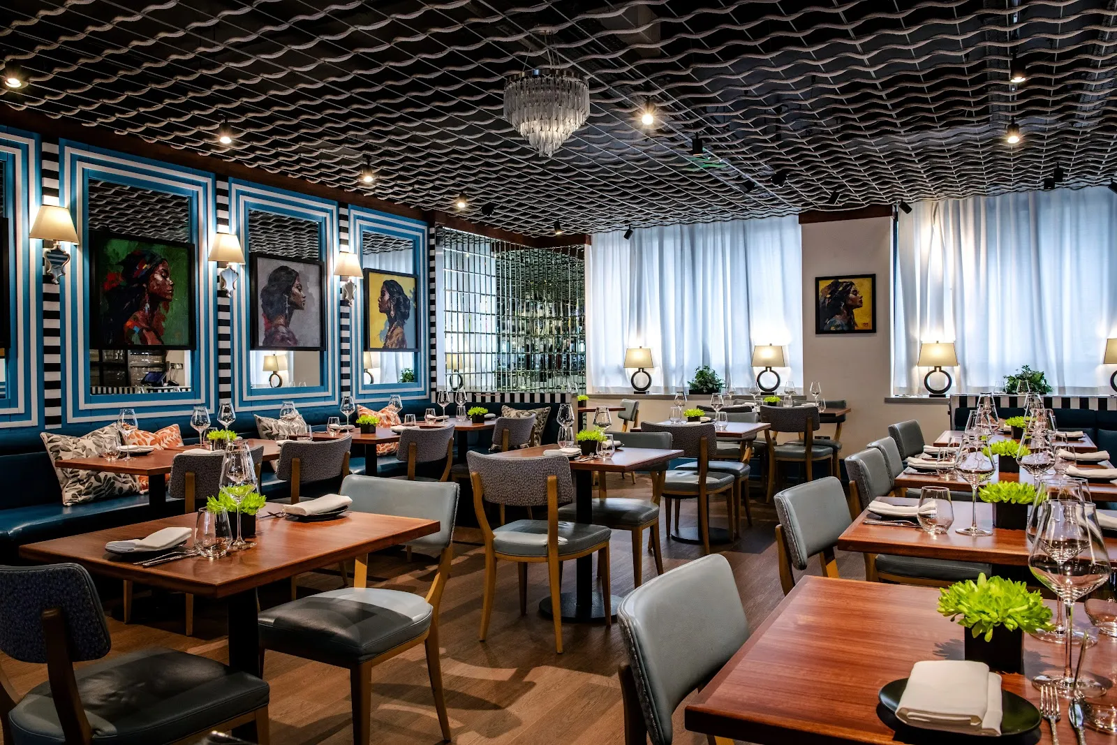 The dining room at Kanishka in Mayfair with blue leather booths, modern pendant lighting and patterned ceiling