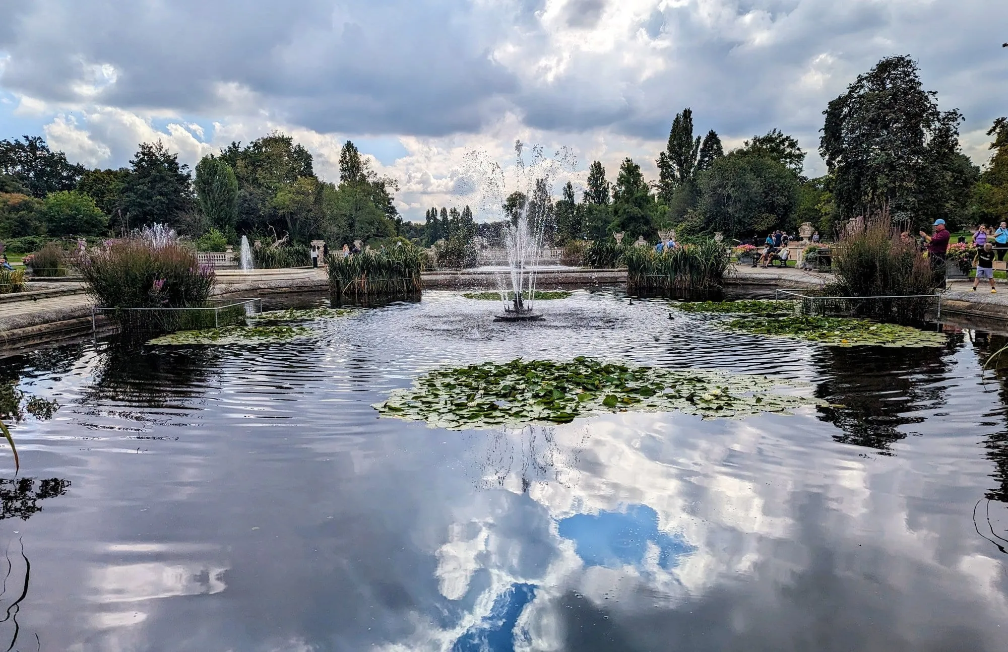 The still, fountain-fed pool of the Italian Gardens in Kensington Gardens, reflecting clouds