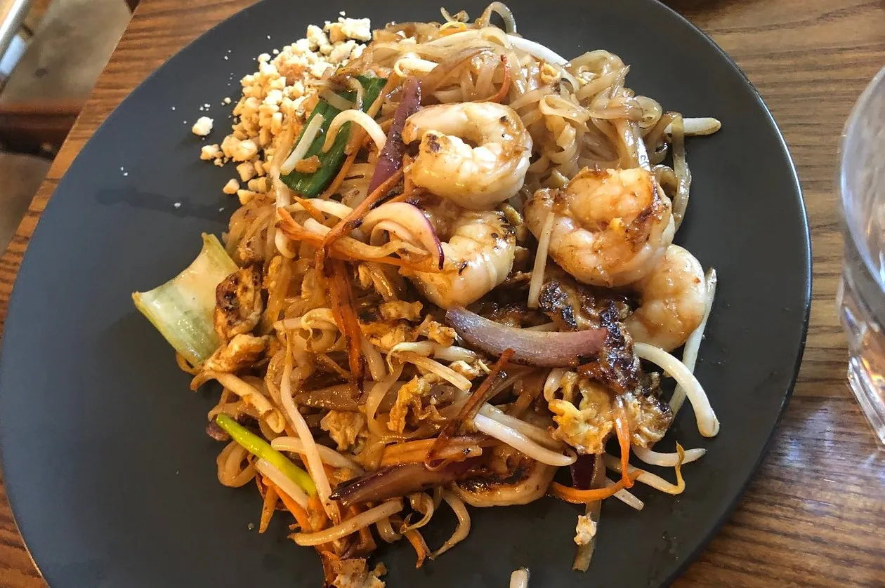 A plate of stir-fried rice noodles with prawns, bean sprouts, egg and crushed peanuts
