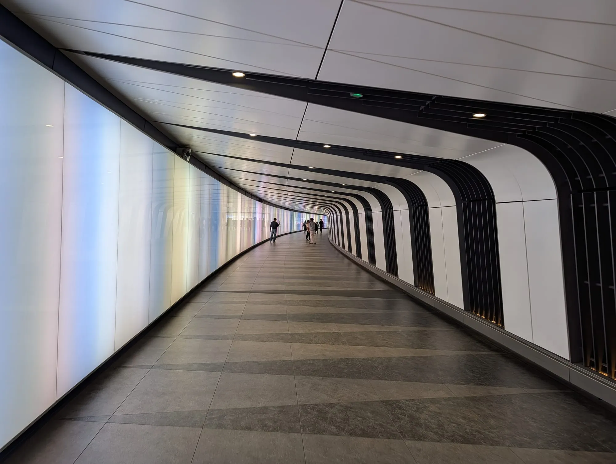 A long curving pedestrian tunnel lined with a colour-changing light wall, linking King's Cross and St Pancras