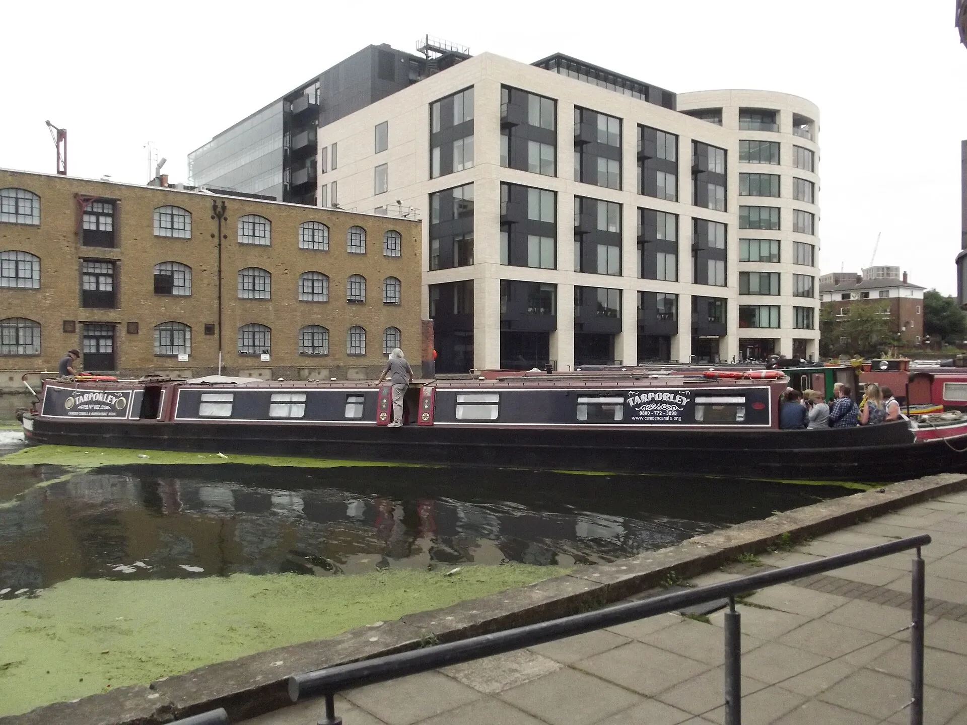 Kings Place seen across Battlebridge Basin, its glass frontage above the water with a narrowboat moored in front