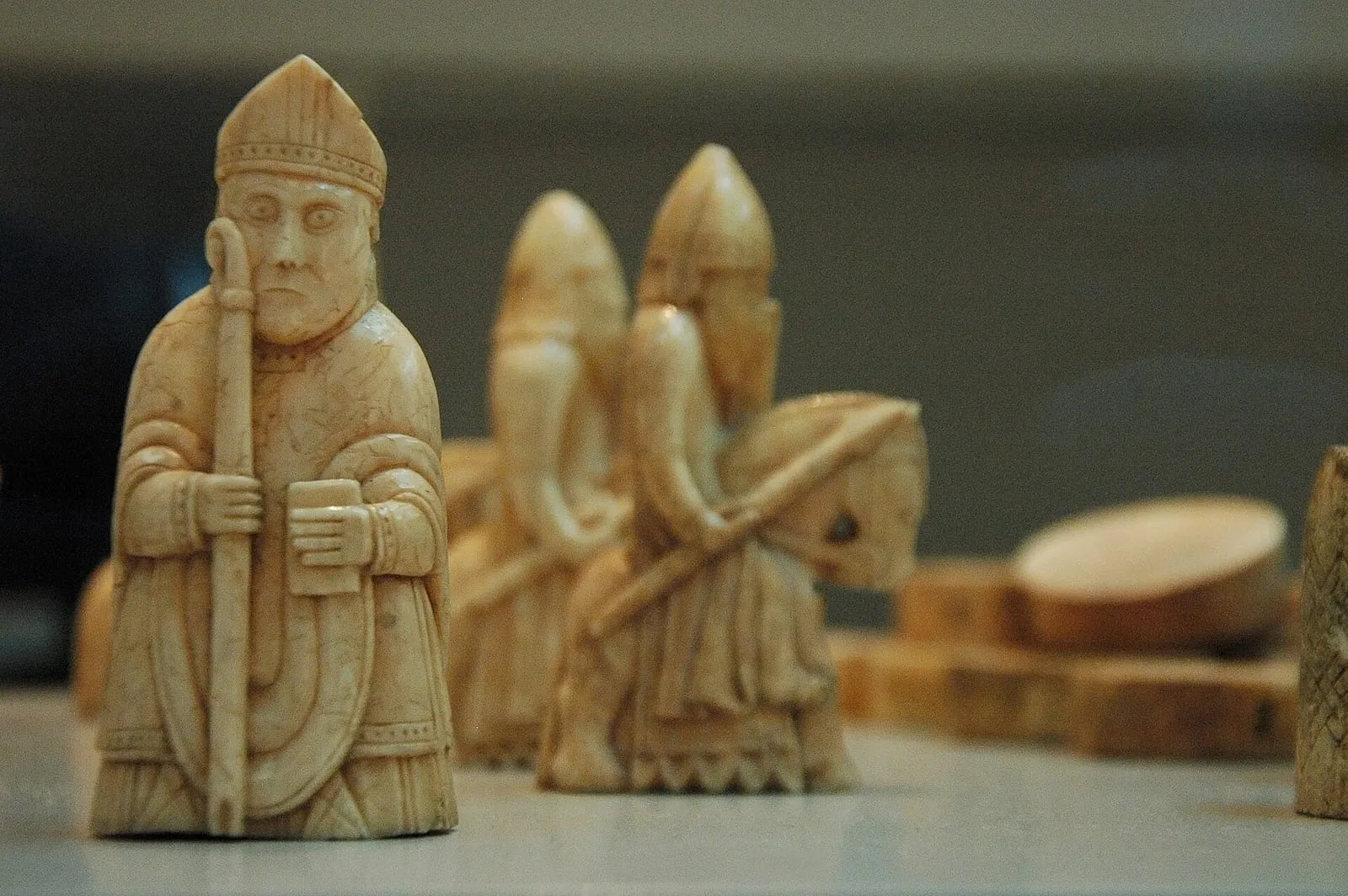Carved ivory Lewis chessmen, a bishop with a crozier in sharp focus in front of mounted knights