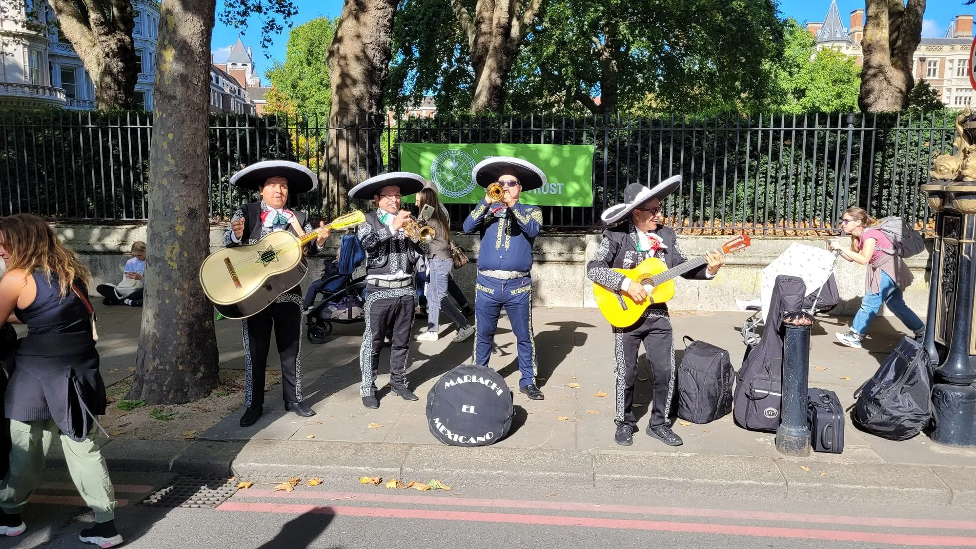 A mariachi band playing on the pavement beside the London Marathon route
