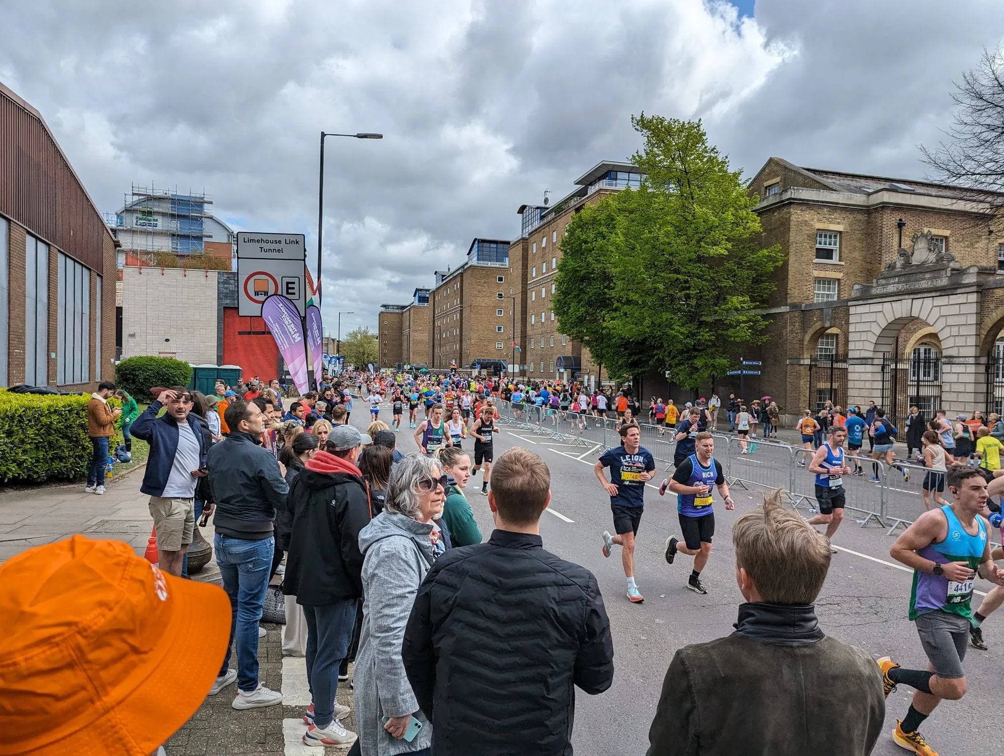 Spectators lining the barriers on the London Marathon course at Limehouse, watching runners stream past