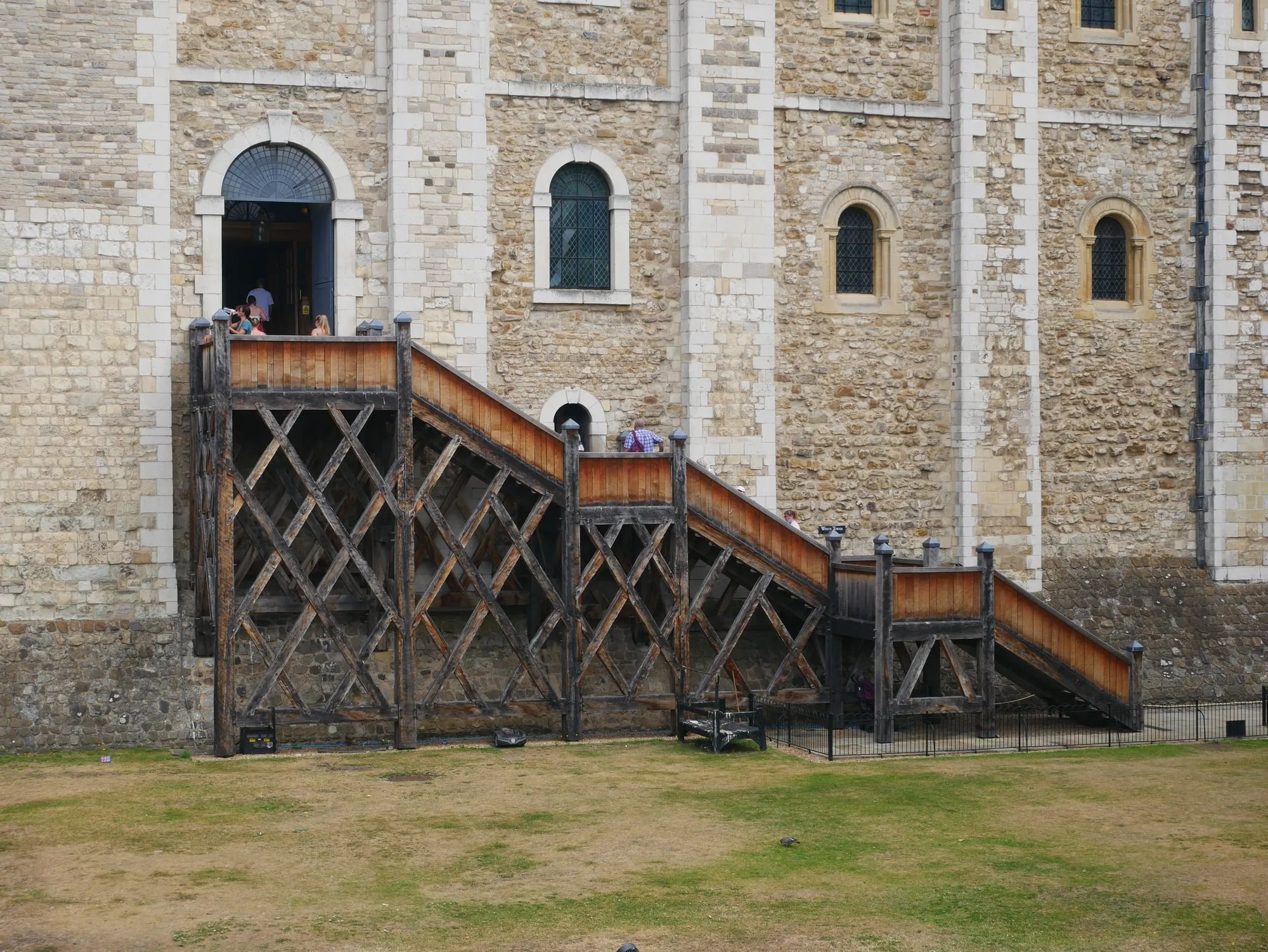 Visitors climbing the wooden entrance stairway to the White Tower at the Tower of London, one of the paid attractions this guide prices against the pass