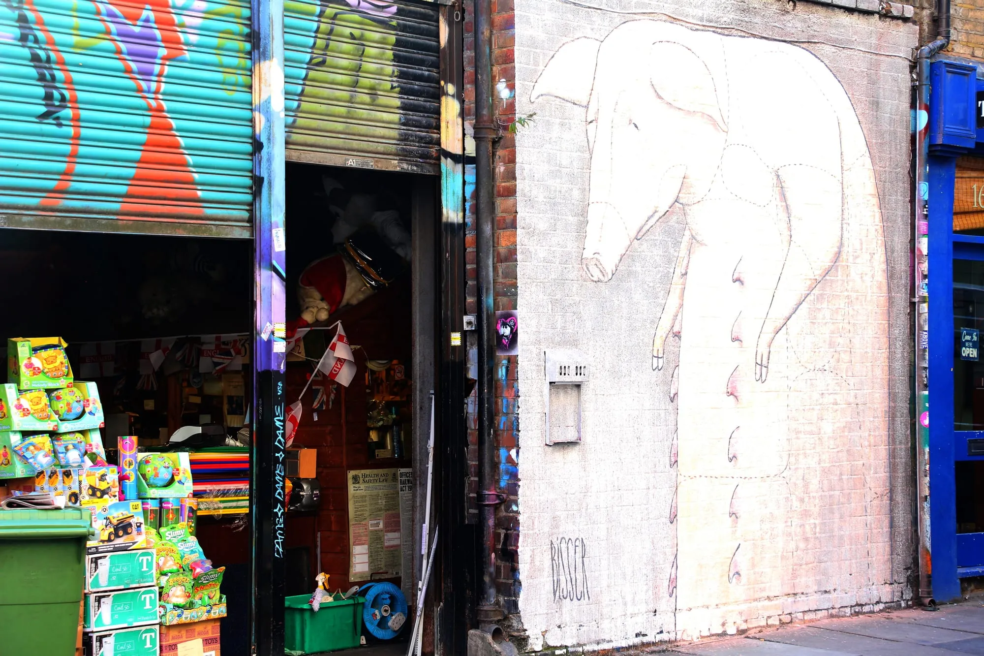A large painted mural covering a brick wall on Bacon Street off Brick Lane