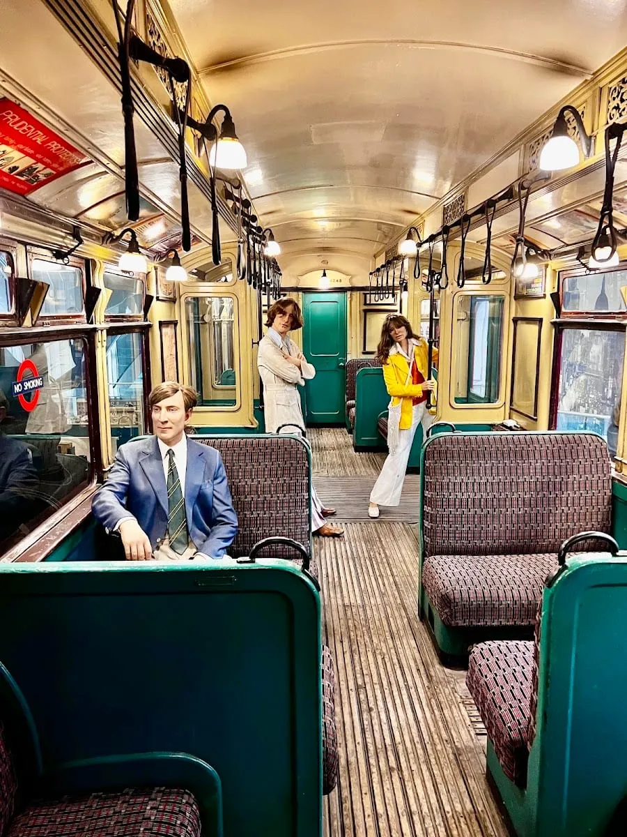 The interior of a preserved vintage Tube carriage on display, with wooden-effect panelling and period seating
