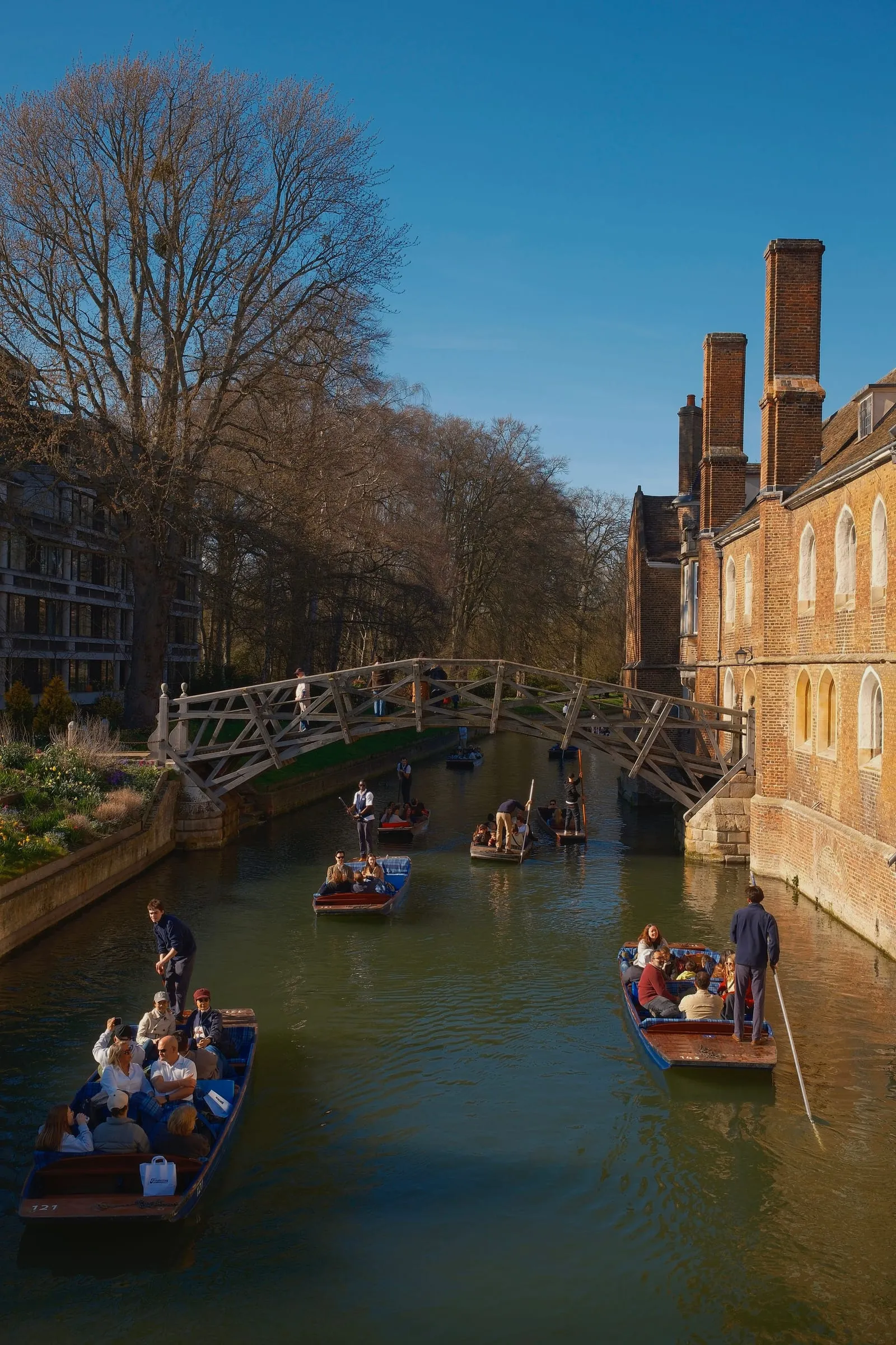 Punts on the River Cam passing under the wooden Mathematical Bridge at Queens' College