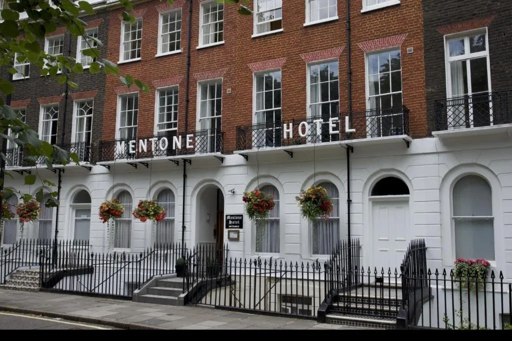 The white-porticoed Georgian townhouse frontage of Mentone Hotel on Cartwright Gardens with black cast-iron railings
