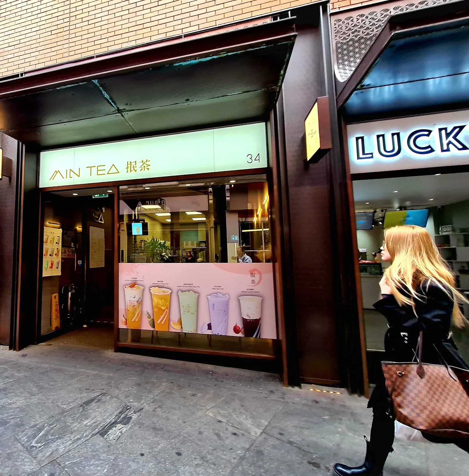 Min Tea's shopfront at number 34 Newport Court, with drinks pictured in the window and Lucky Tea's sign on the shop next door