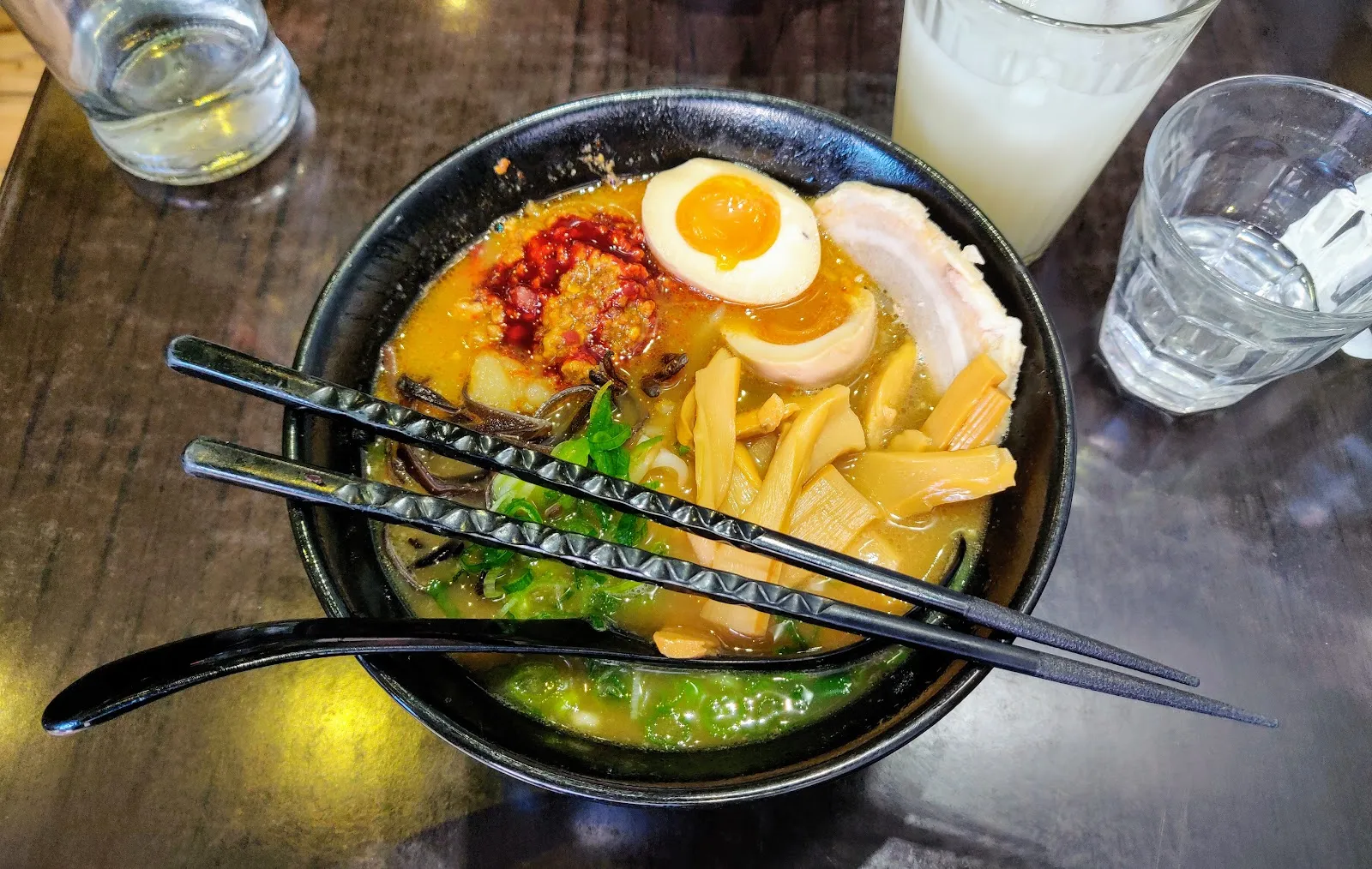 A bowl of ramen with a marinated egg, chashu and chilli oil at Monohon Ramen