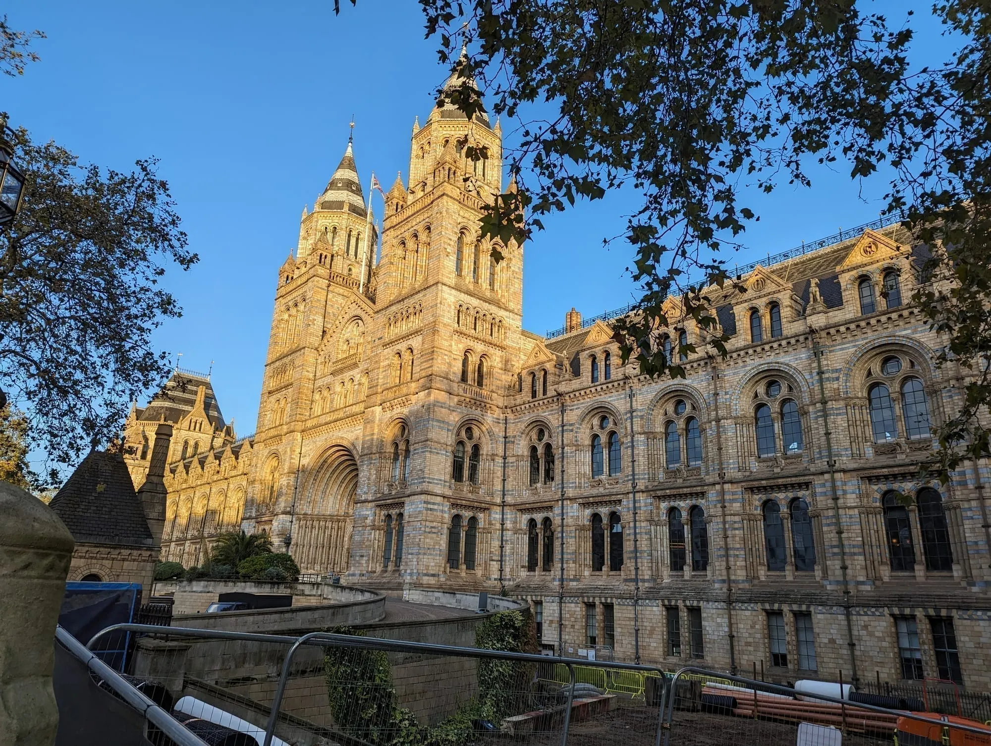The terracotta towers of the Natural History Museum lit by low evening sun