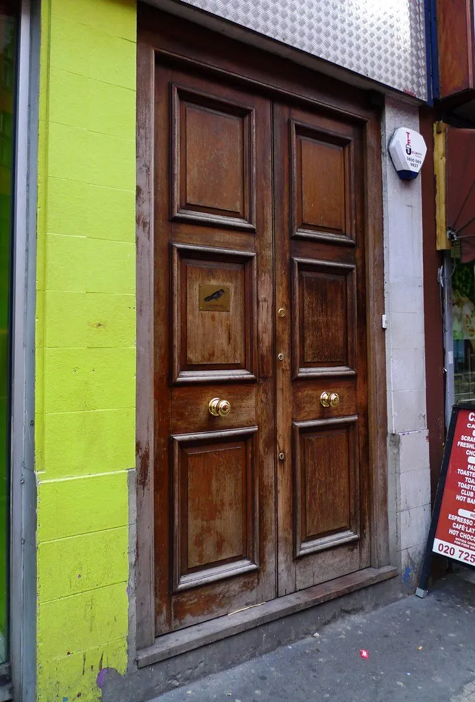 An unmarked wooden door beside a green wall
