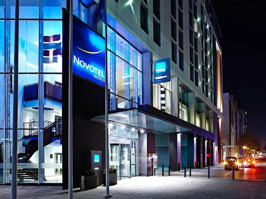 The entrance of Novotel London ExCeL at night, under the lit Novotel sign