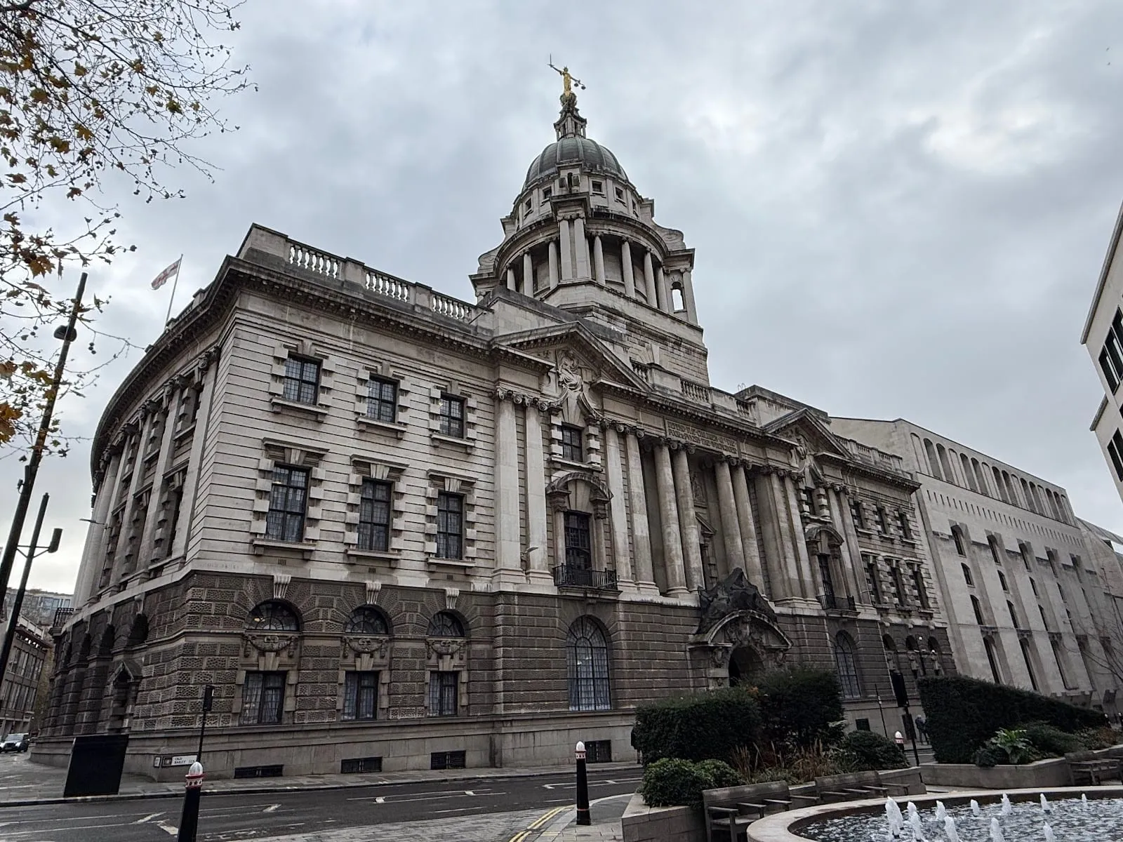 The Central Criminal Court on a grey day, its stone dome topped by the gilded figure of Justice holding scales and a sword