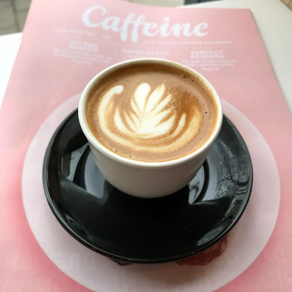 A cappuccino in a blue cup on a wooden table