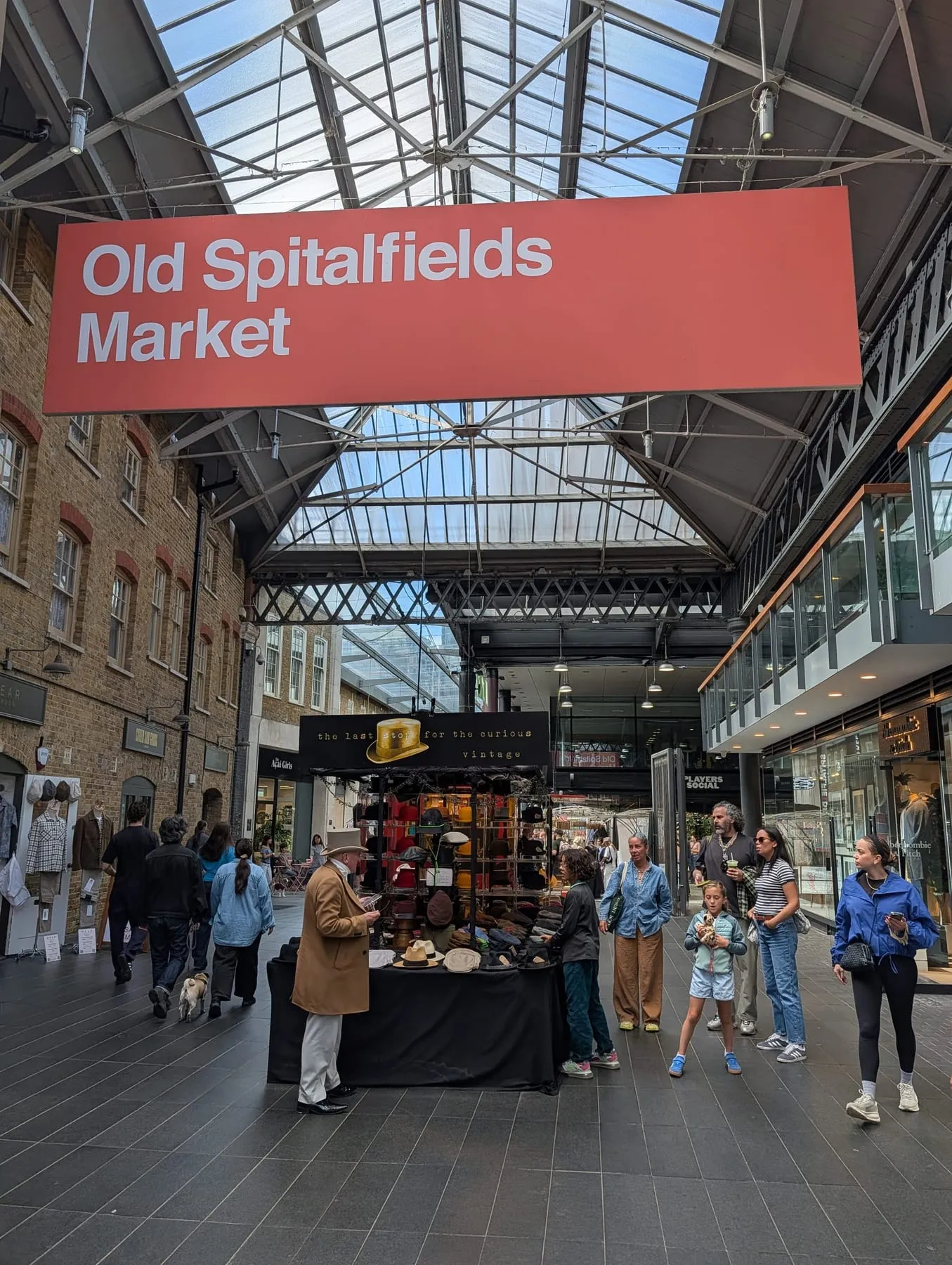 Stalls and browsing shoppers under the roof at Old Spitalfields Market