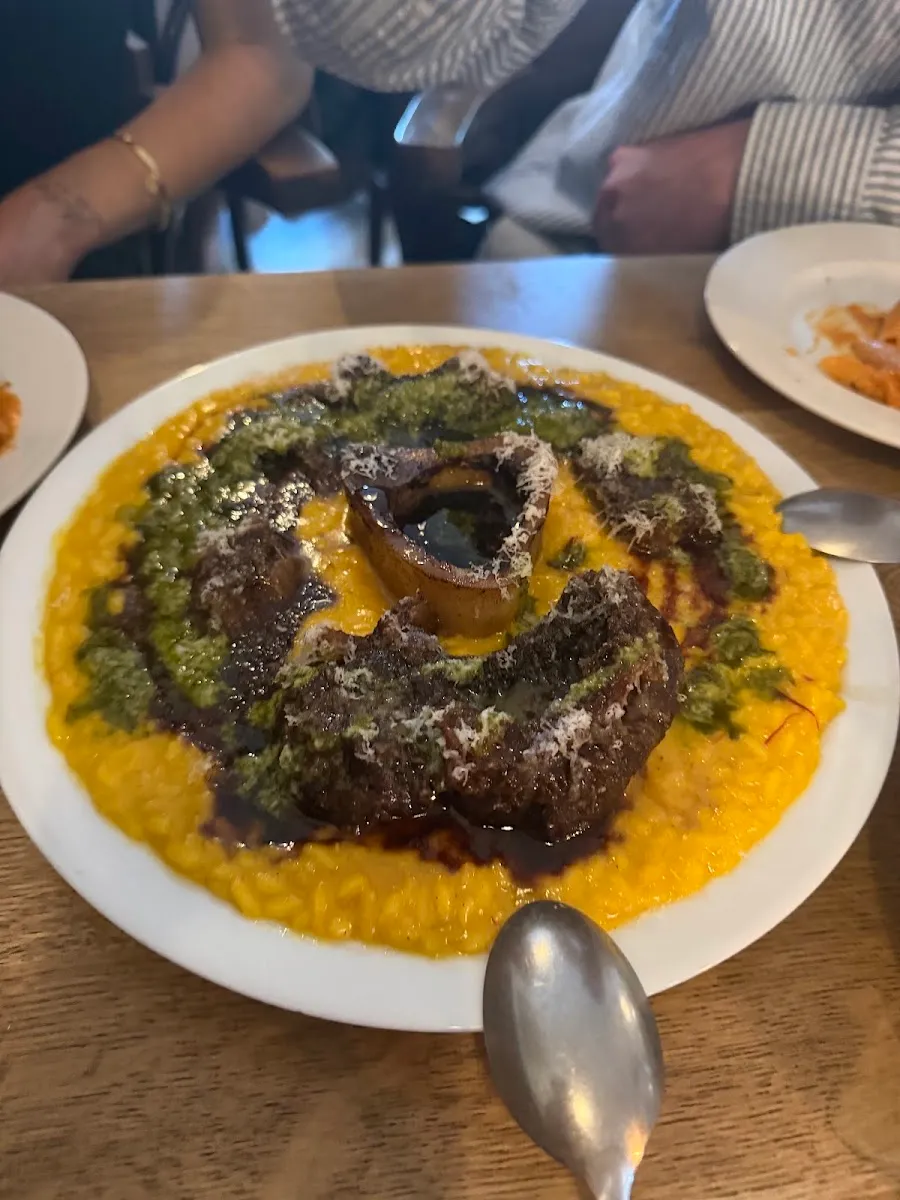 Saffron-yellow risotto alla milanese topped with a braised, bone-in veal shank and gremolata