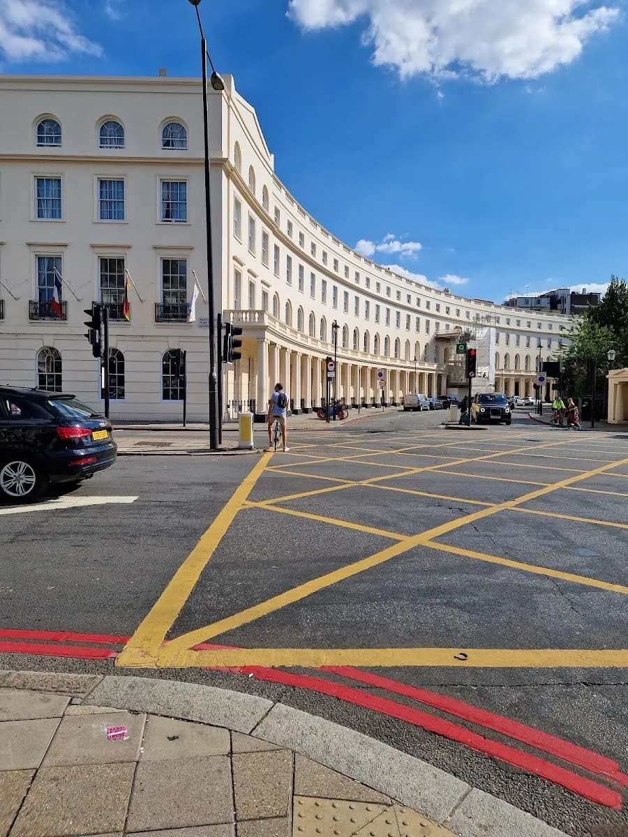 The curved cream stucco facade of Park Crescent, with ground-floor columns and the road curving round it