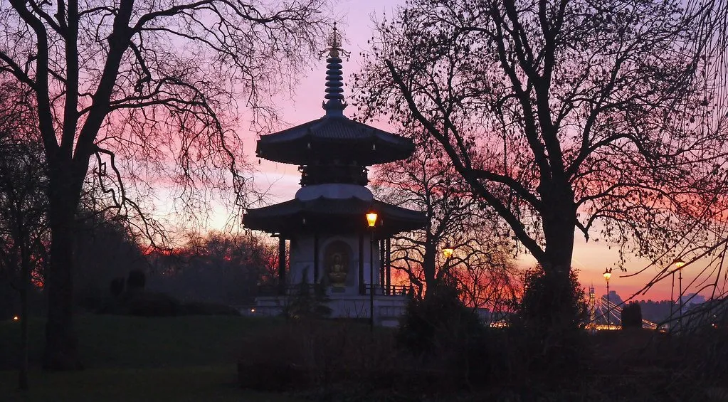 The Japanese Peace Pagoda in Battersea Park silhouetted against a pink and orange sunset