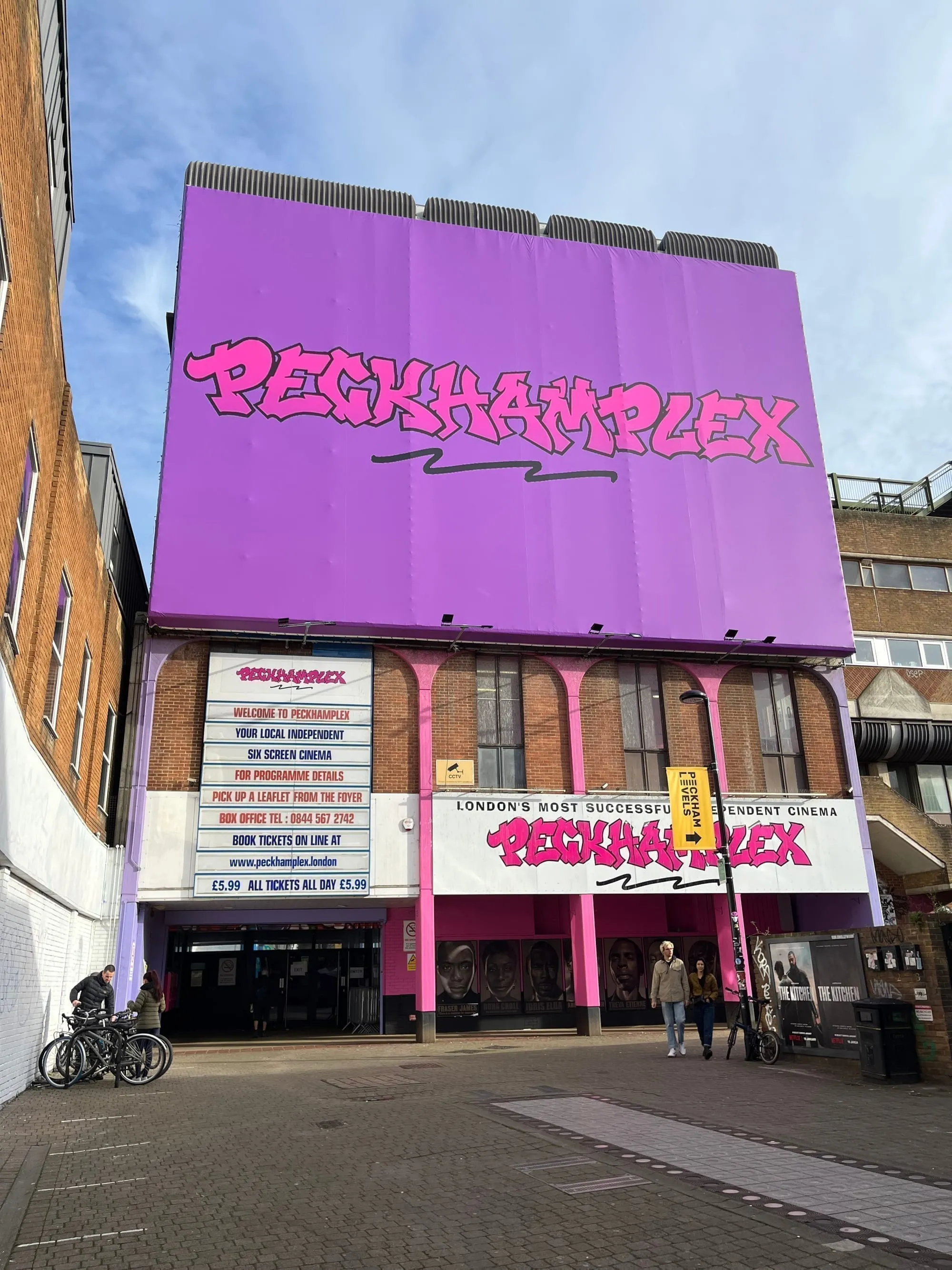 The purple and pink frontage of Peckhamplex cinema in Peckham, with its listings board and film posters