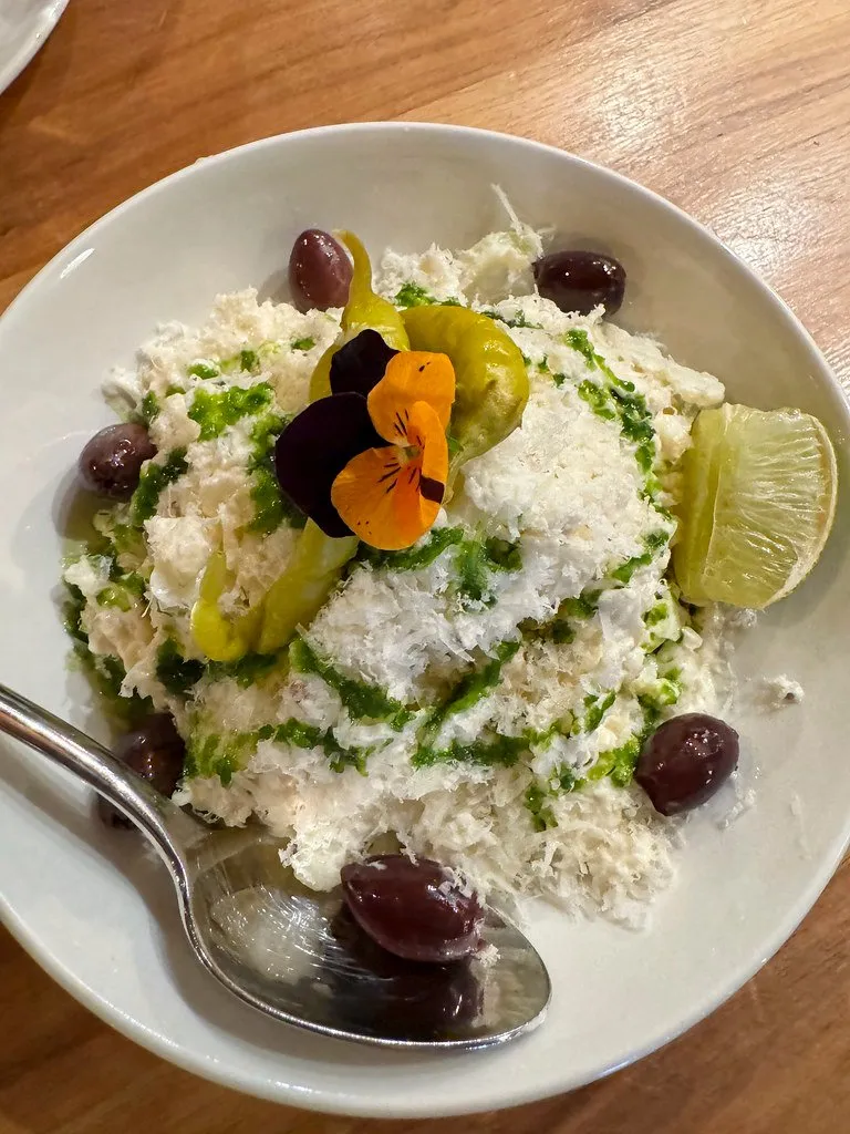 Crab with olives and herbs on a white plate