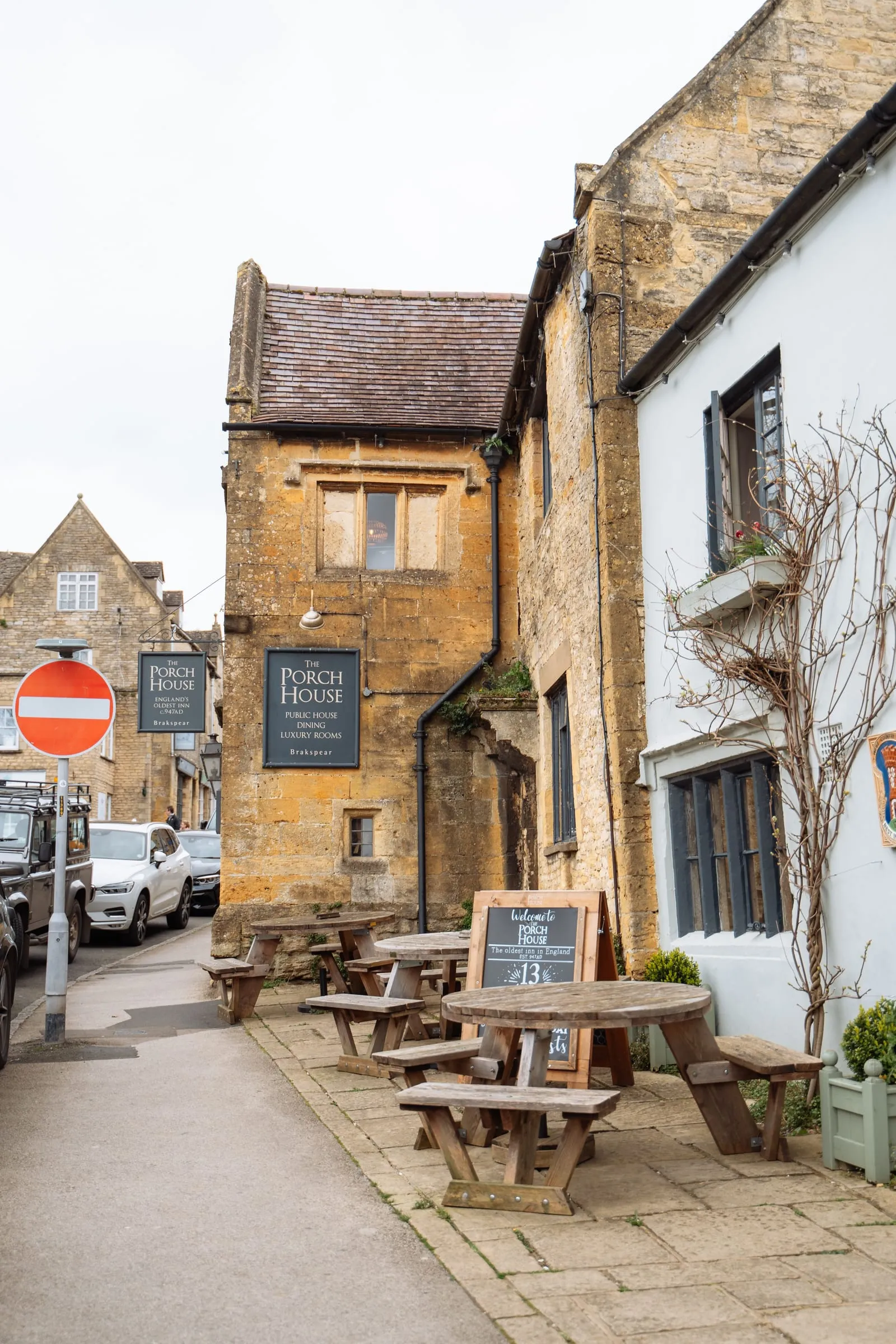 The Porch House at Stow-on-the-Wold, a honey-stone inn with its sign over the pavement
