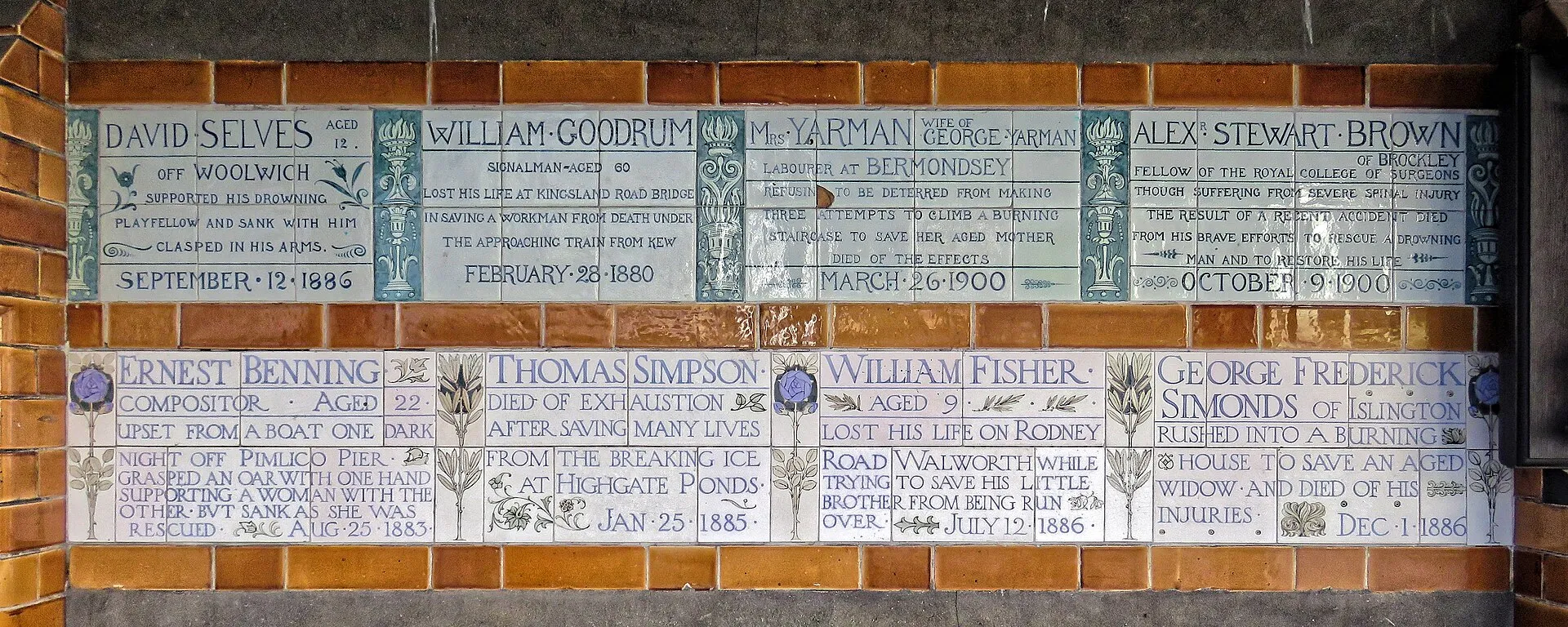 Two rows of hand-painted ceramic tablets set in amber glazed tiles, each recording a person who died saving someone else