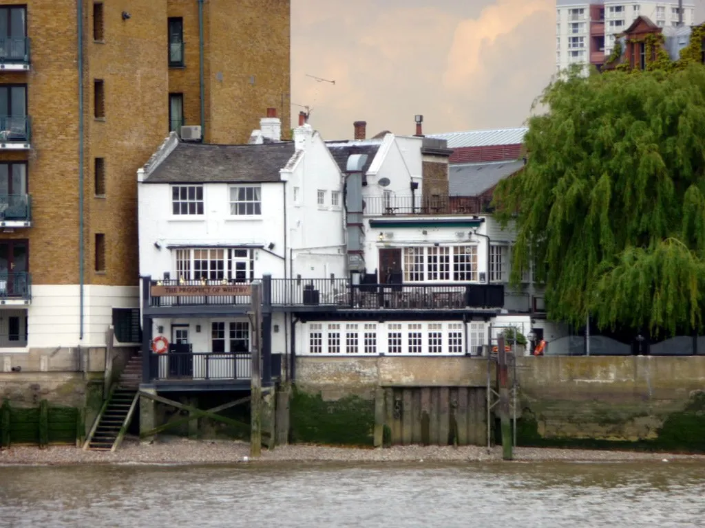 The white weatherboarded Prospect of Whitby pub seen from the Thames at low tide