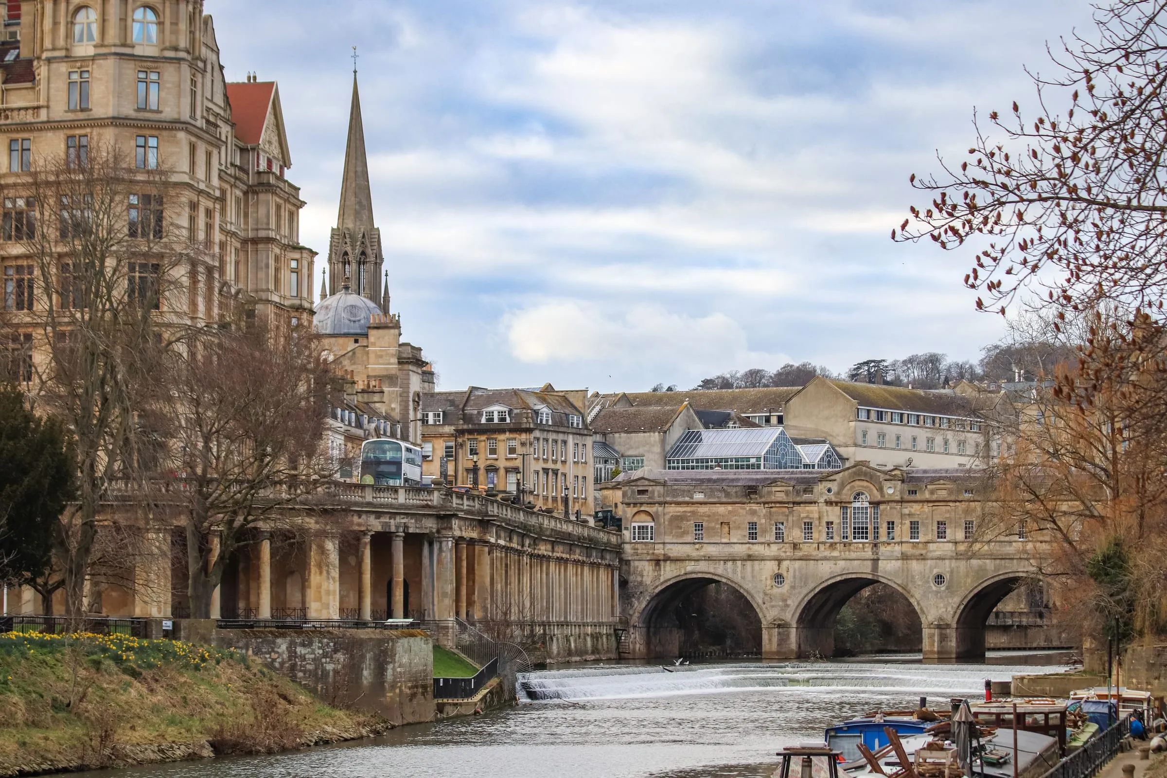 Pulteney Bridge seen from the river, its arches and the shops built along it, with Georgian buildings behind