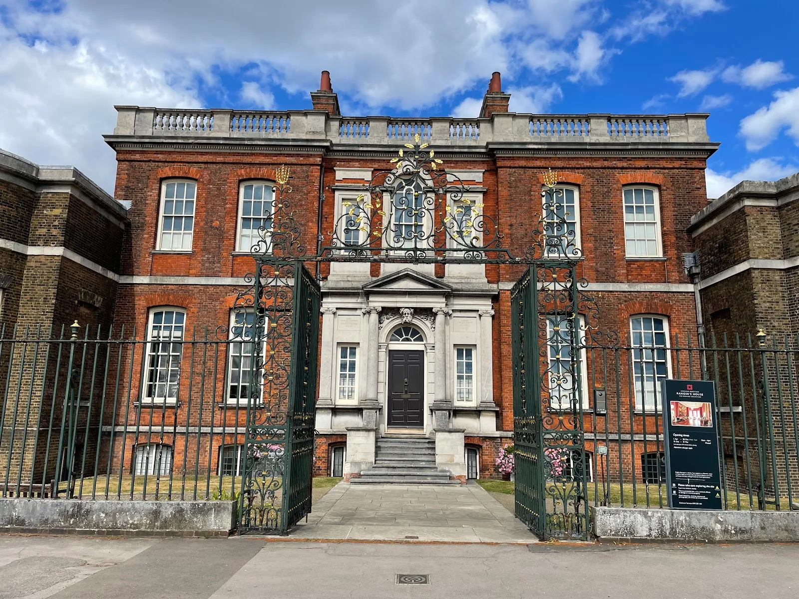 Ranger's House in Greenwich Park, a red-brick Georgian villa seen through its wrought-iron entrance gates