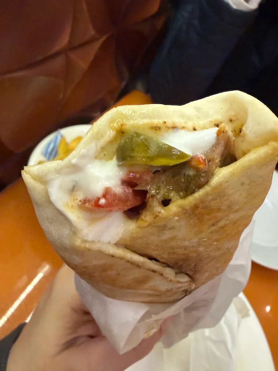 A chicken shawarma wrap at Ranoush Juice, filled with garlic sauce, pickle and carved meat