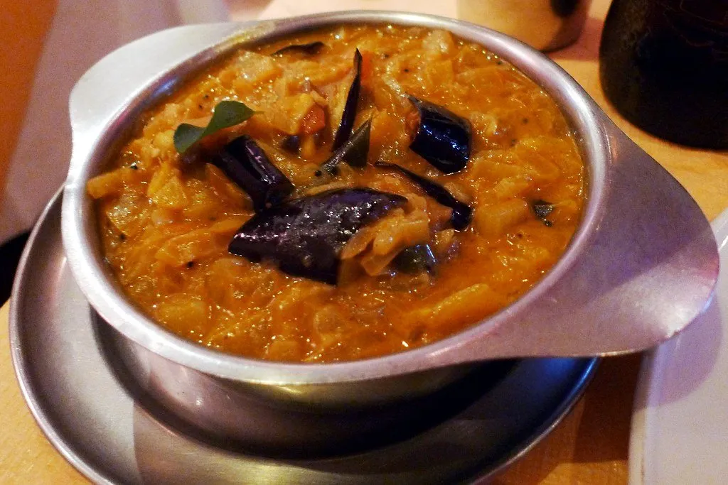 A bowl of aubergine curry in a steel dish