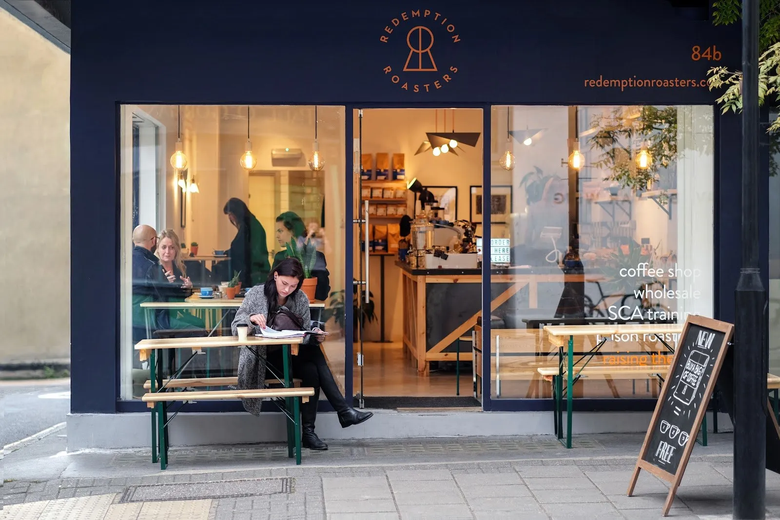 The glazed shopfront of Redemption Roasters with customers seated at benches inside