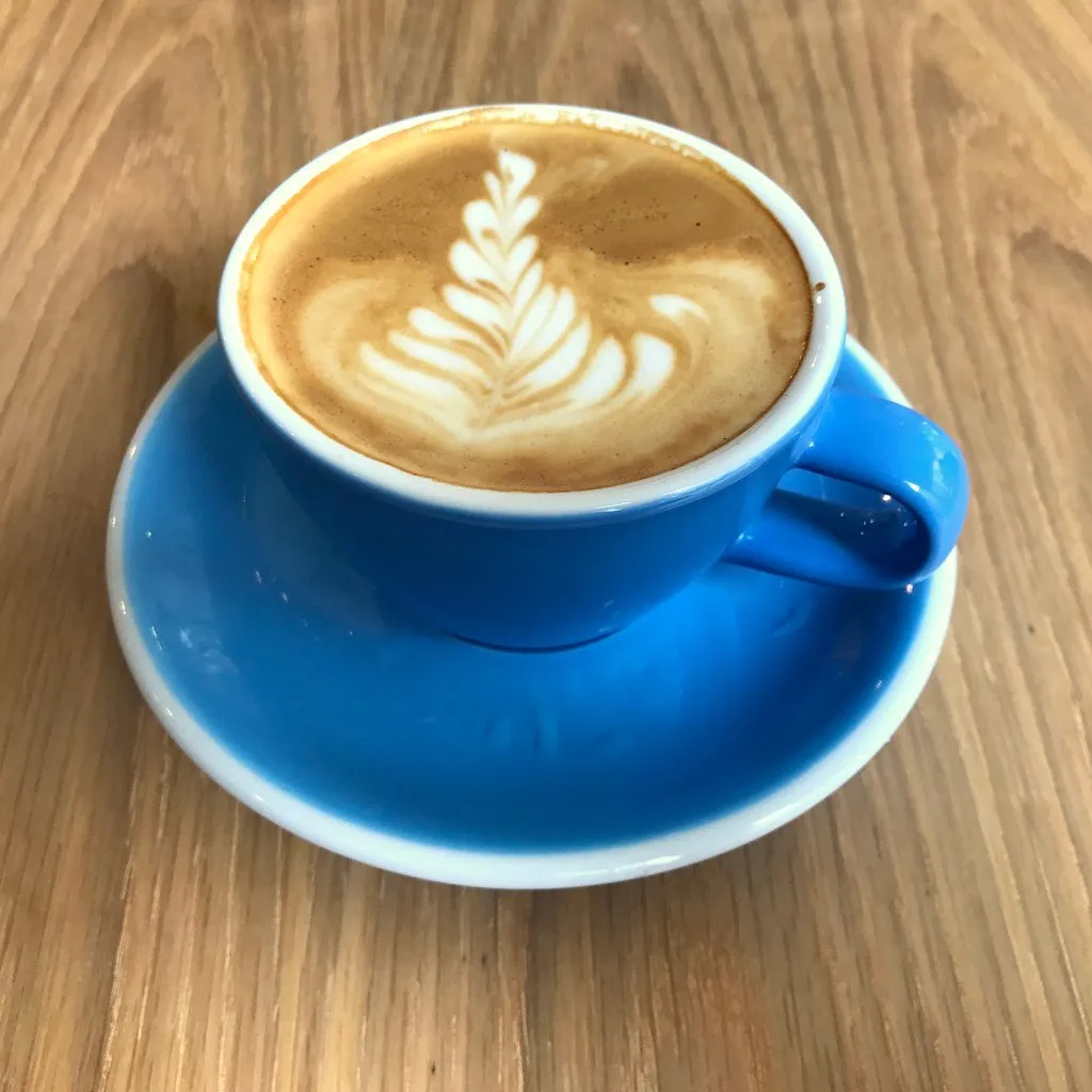 A cappuccino in a blue cup