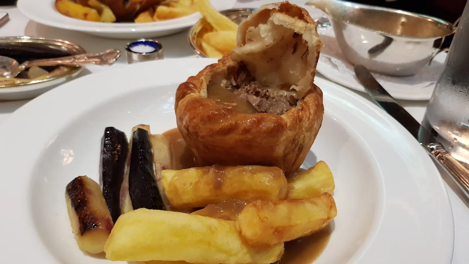 A steak and kidney pudding in suet pastry with chips and gravy at Rules