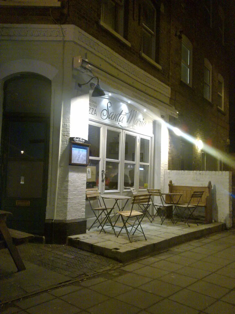 The white frontage of Santa Maria pizzeria at night