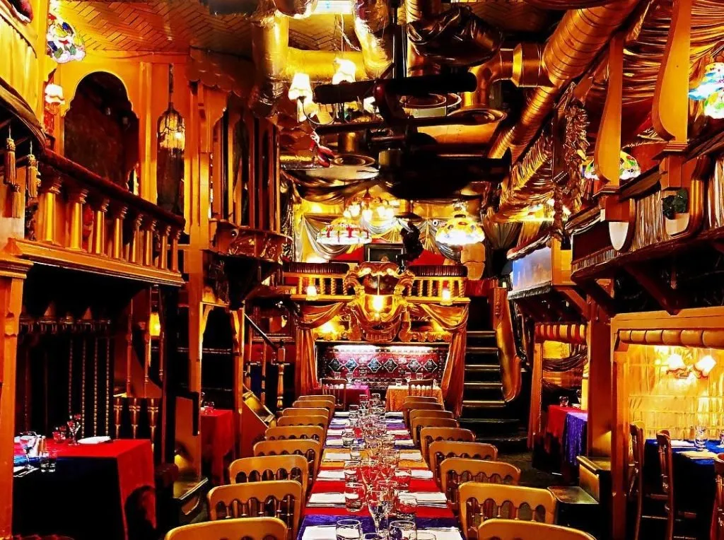 Sarastro's long dining room, with gilded opera-box balconies and a table laid down the centre
