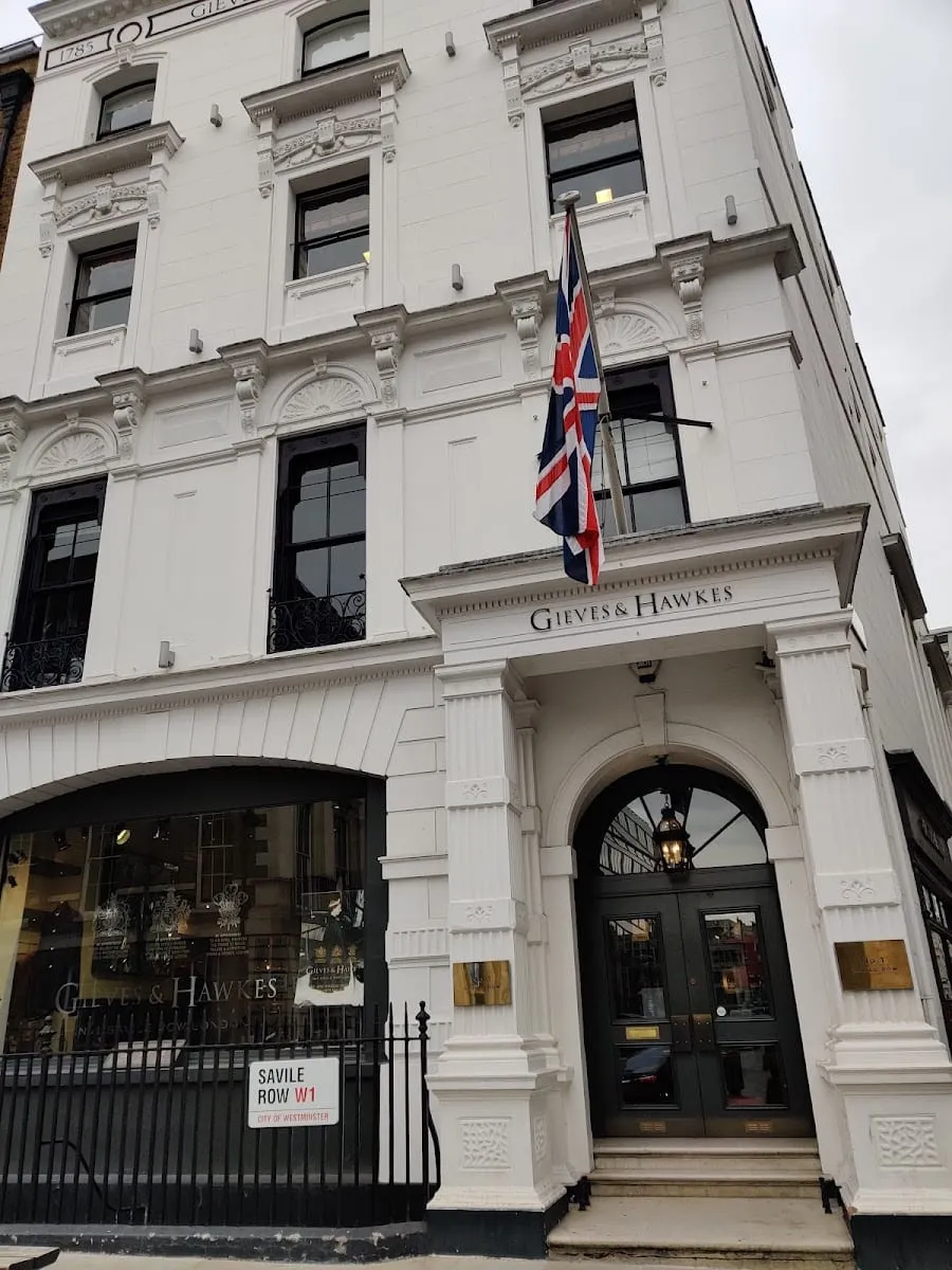 The white stone frontage of Gieves & Hawkes at No. 1 Savile Row, with a Union flag above the entrance