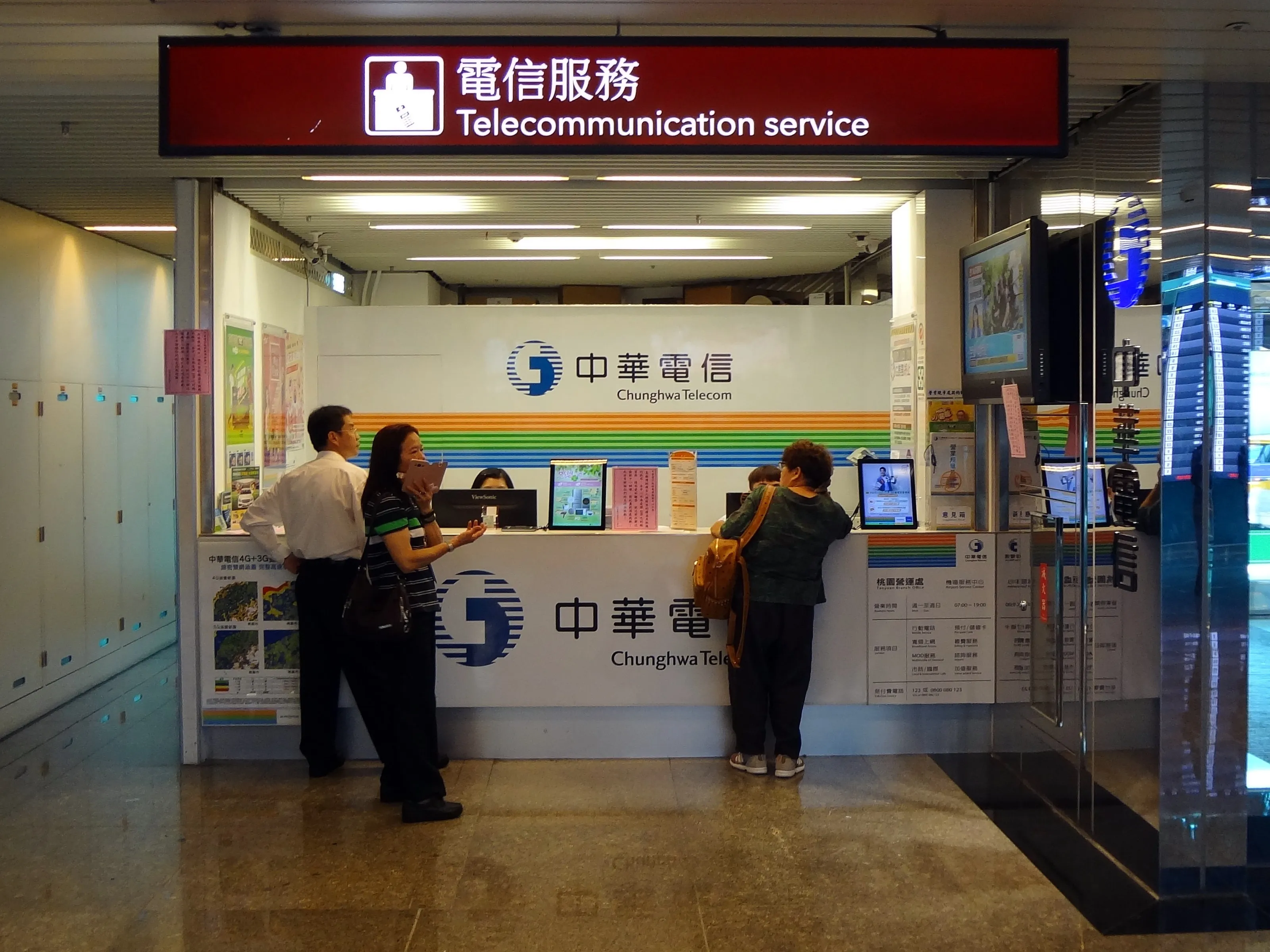 Travellers at a mobile-network service counter inside an airport