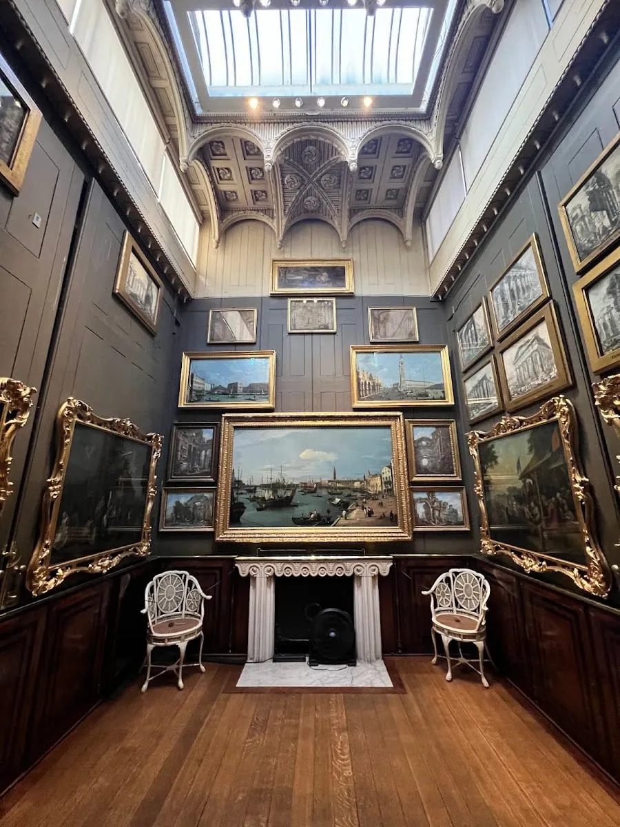 The Picture Room at Sir John Soane's Museum, with gilt-framed paintings hung from floor to ceiling on dark walls below a skylight