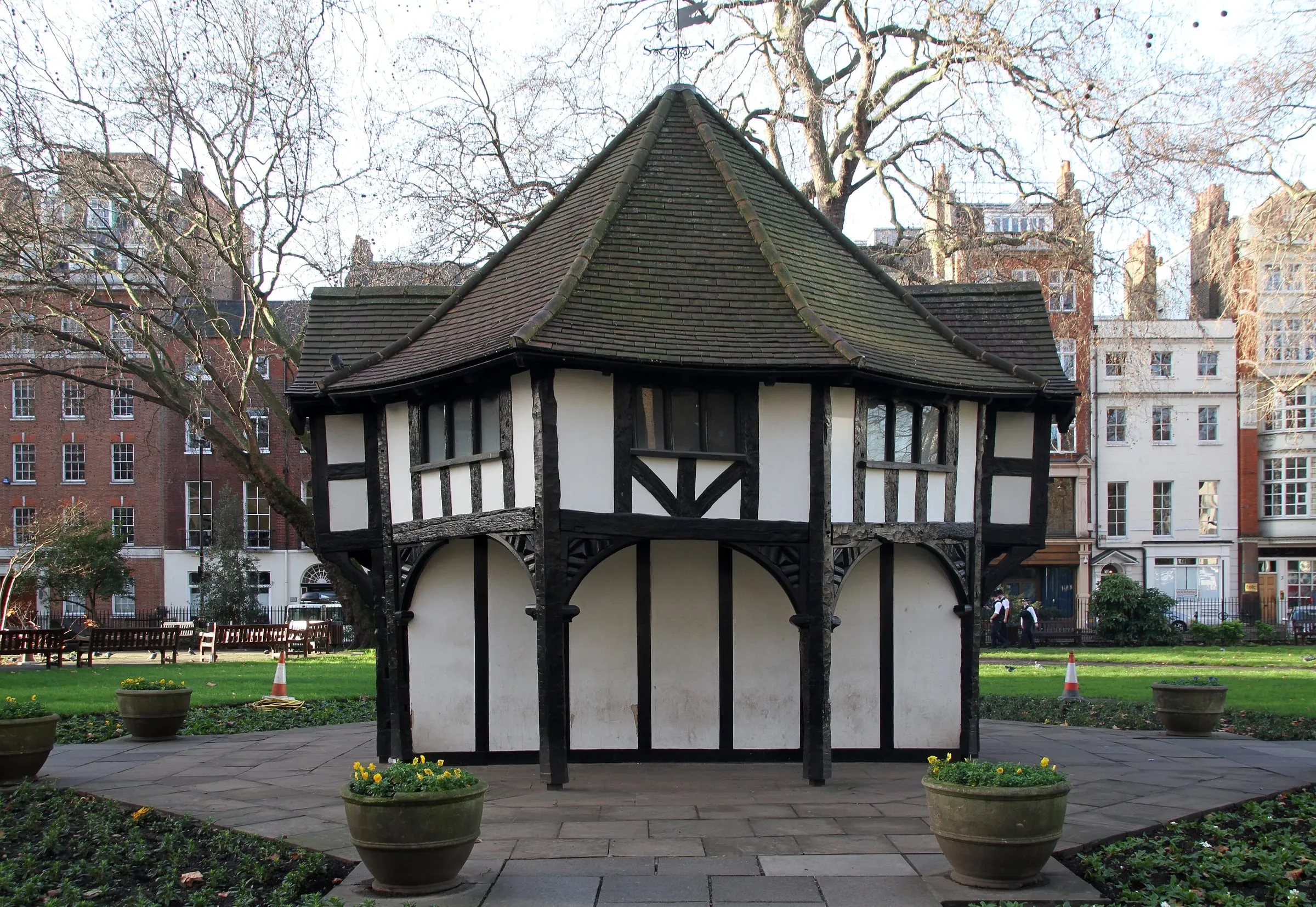 The black-and-white half-timbered gardener's hut in the middle of Soho Square, with Georgian houses behind