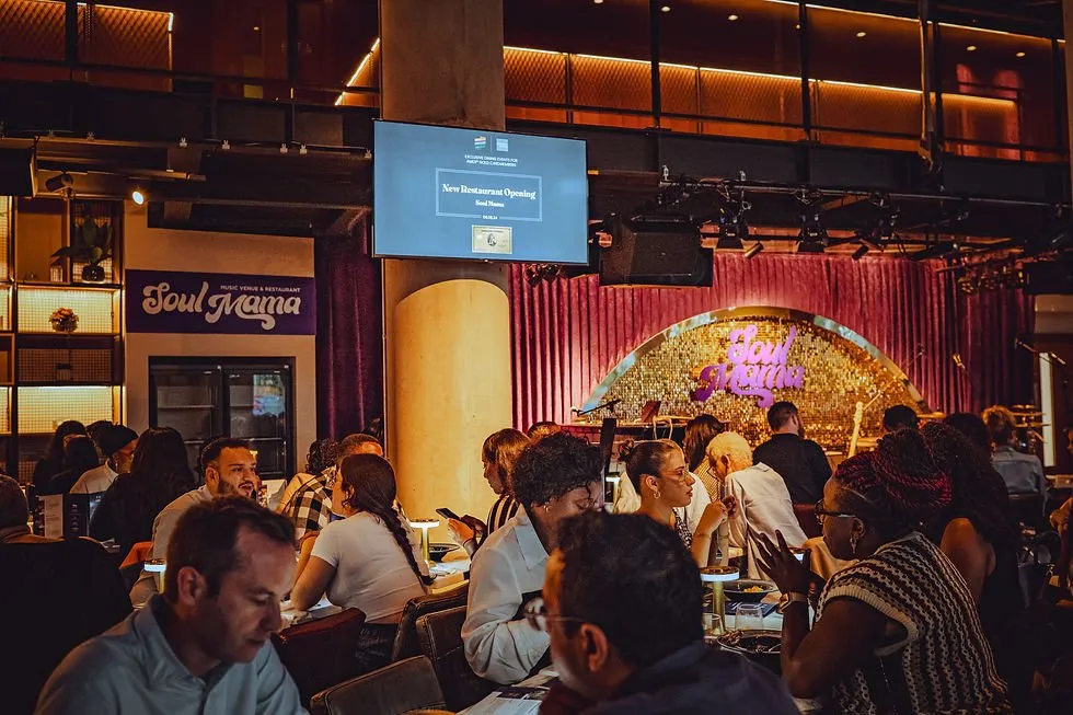 Diners at tables in Soul Mama, with the glittering Soul Mama stage behind them