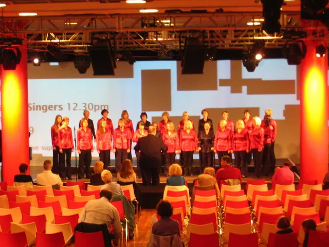 The Charles Clore Ballroom on the ground floor of the Royal Festival Hall, an open space with a low stage and people standing to watch