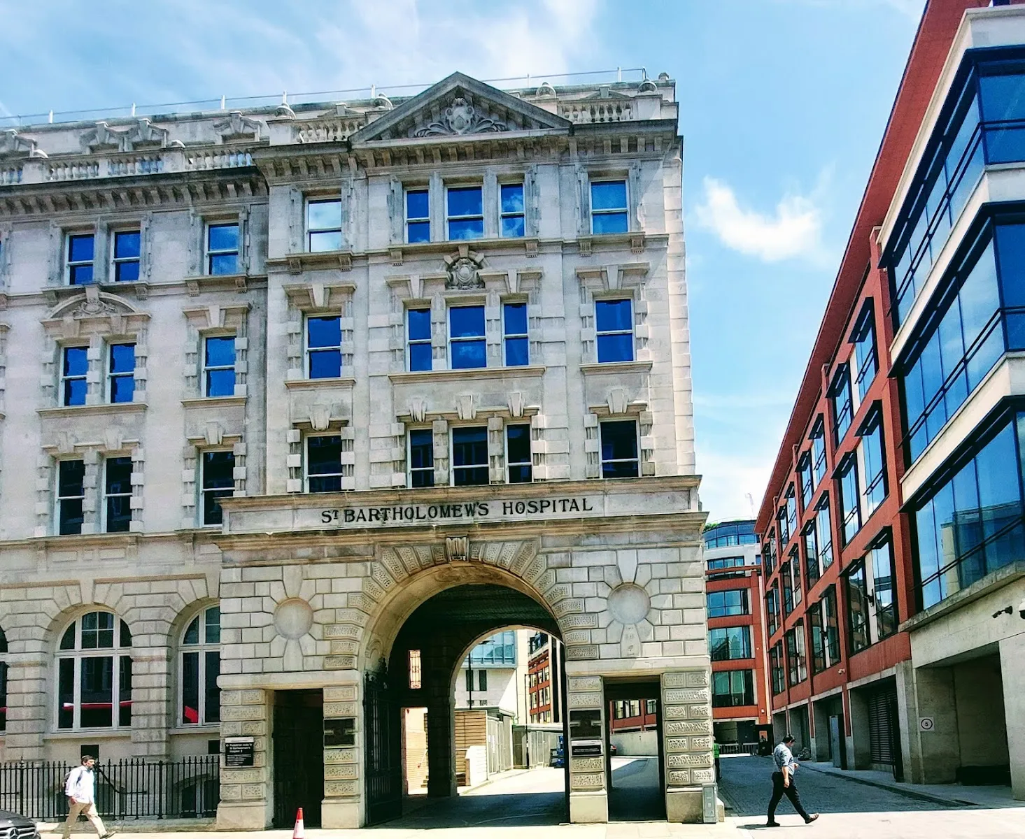 The stone archway entrance to St Bartholomew's Hospital in West Smithfield, with its name carved above the gate