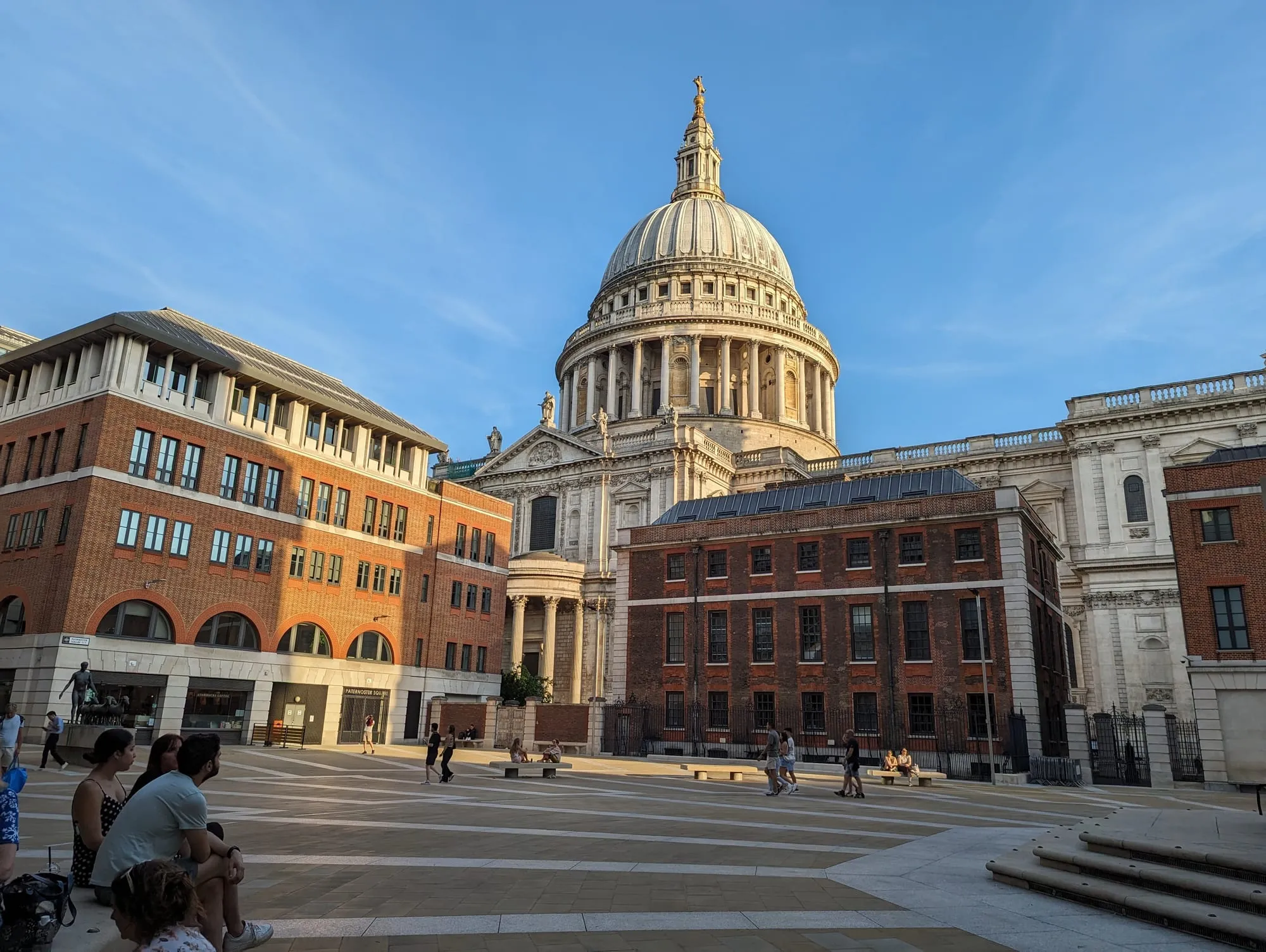 The dome of St Paul's Cathedral rising above Paternoster Square in evening light